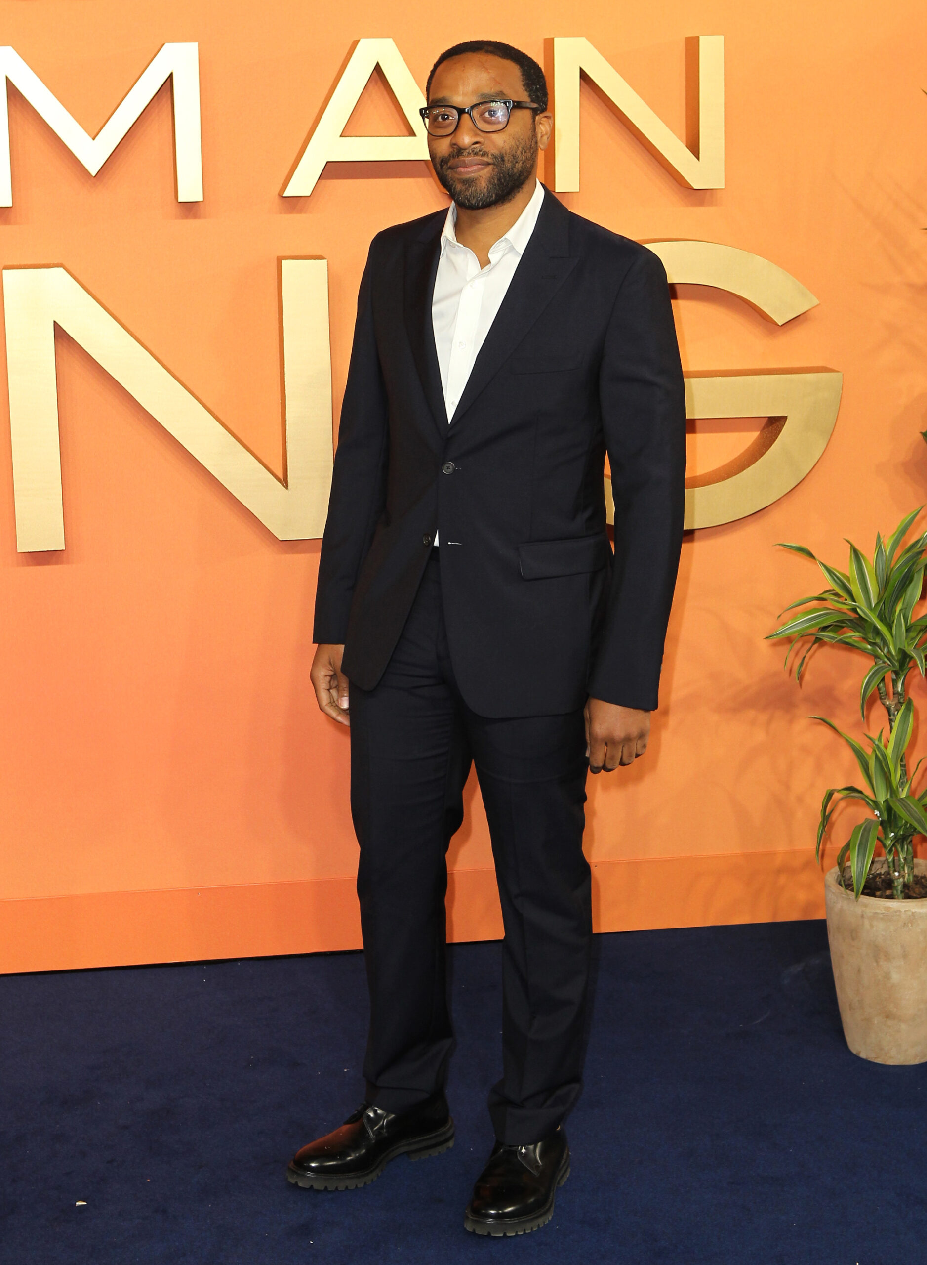 Chiwetel Ejofor wearing glasses and a suit at a film premiere