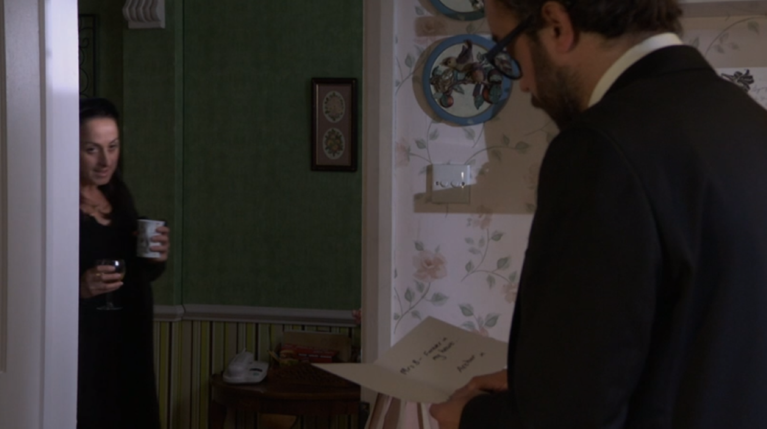 Reiss reading a condolences card in EastEnders