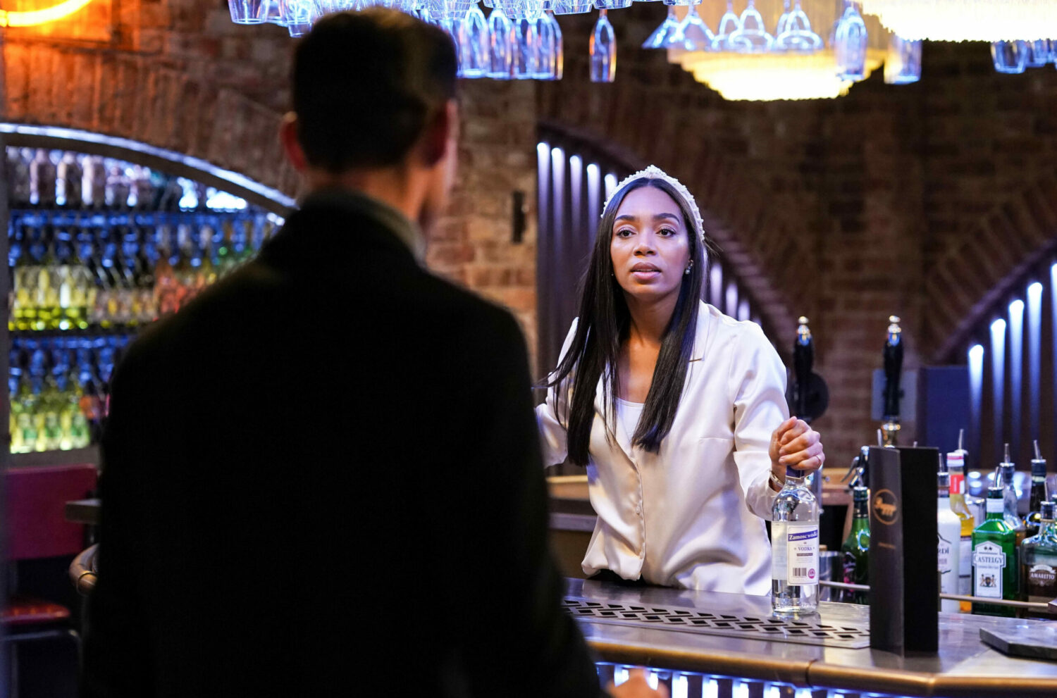 Zack and Chelsea are staring at each other at the bar
