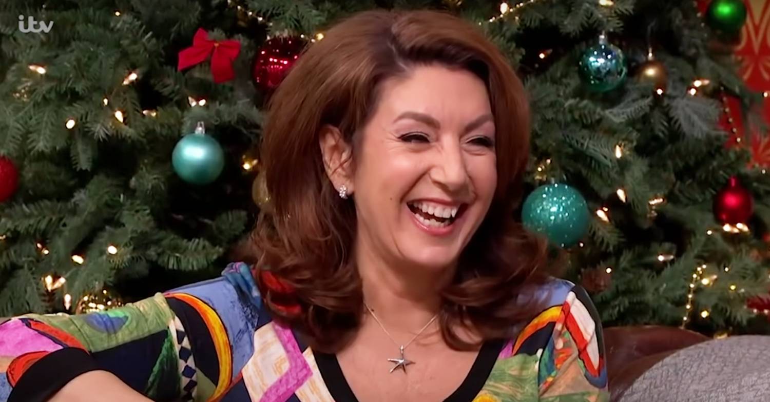 Jane McDonald smiles with a Christmas tree behind her