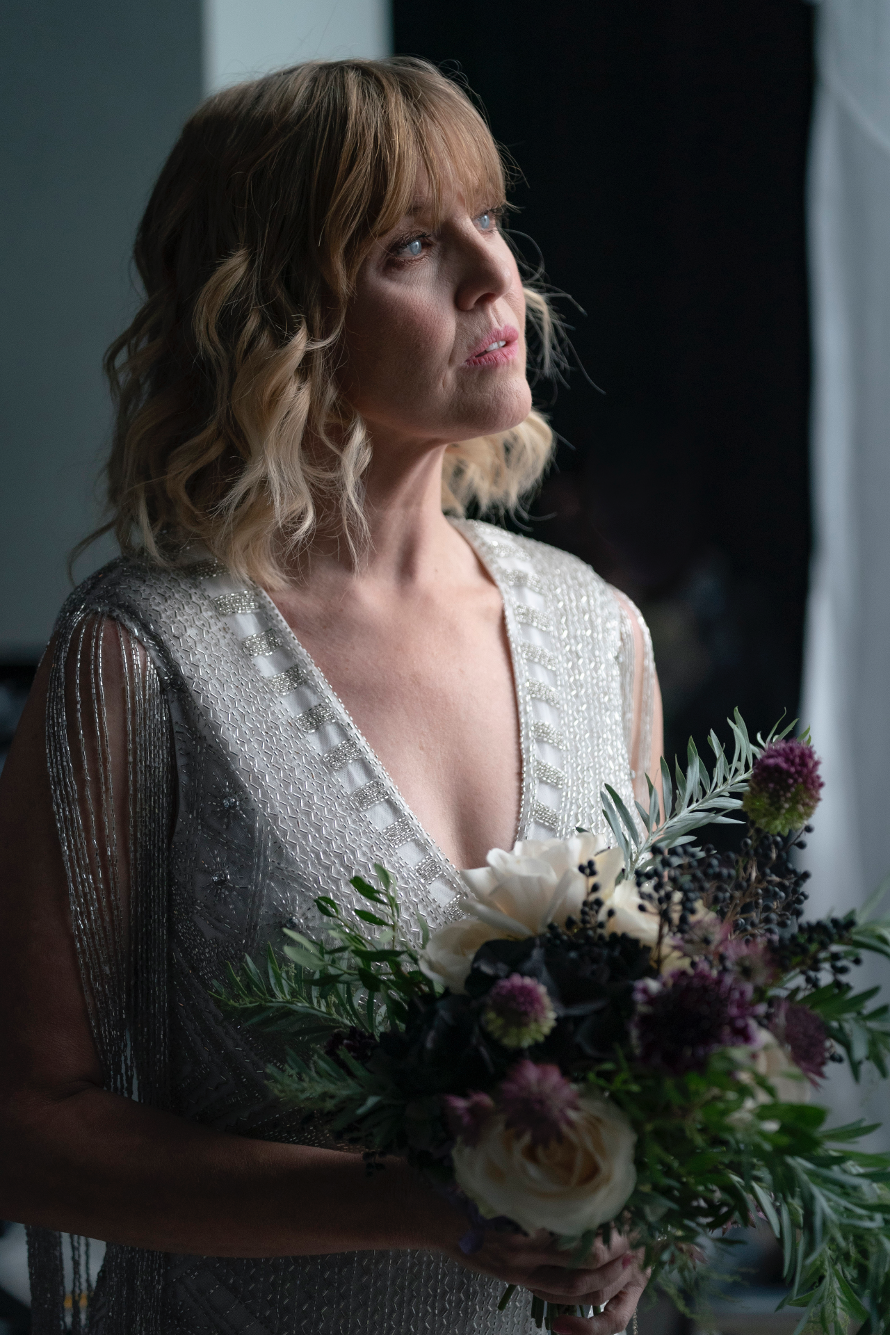 Ashley Jensen holding a bouquet in Mayflies