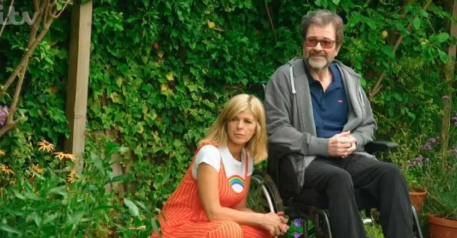 Kate crouches next to Derek's wheelchair