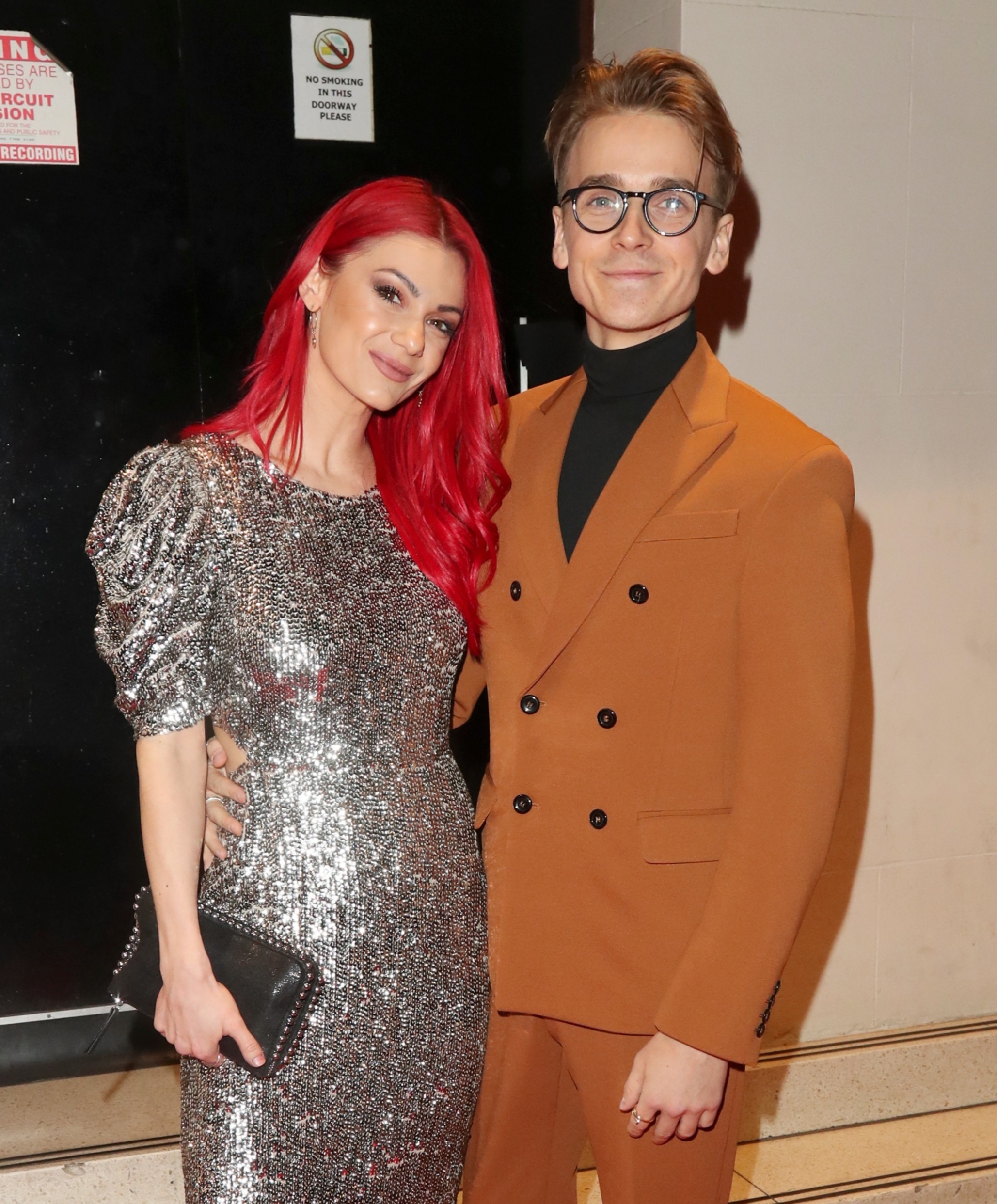 Dianne Buswell wearing a silver glittered dress and Joe Sugg wearing a mute orange suit. 