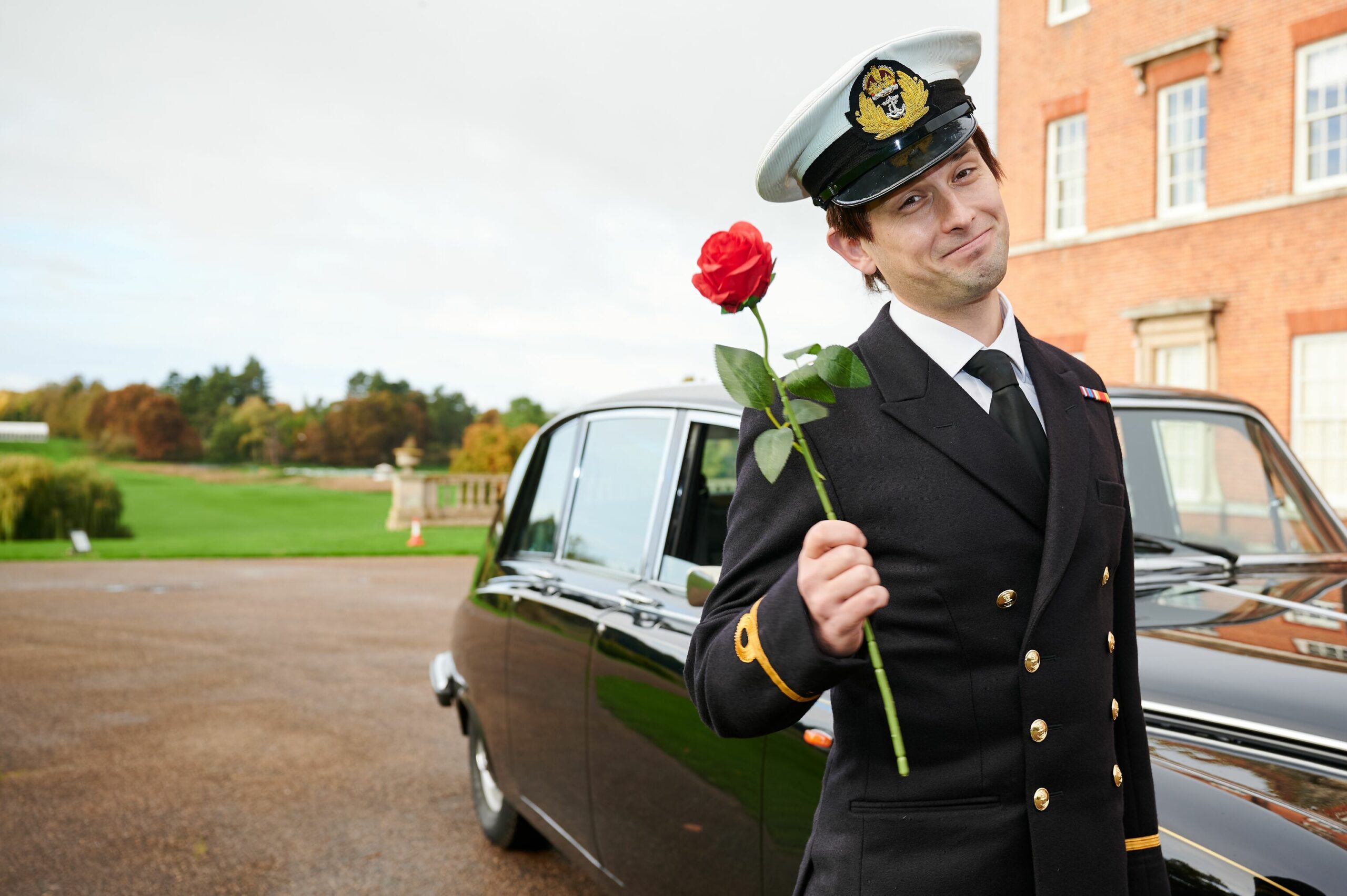Prince Andrew smiles with a rose in the musical