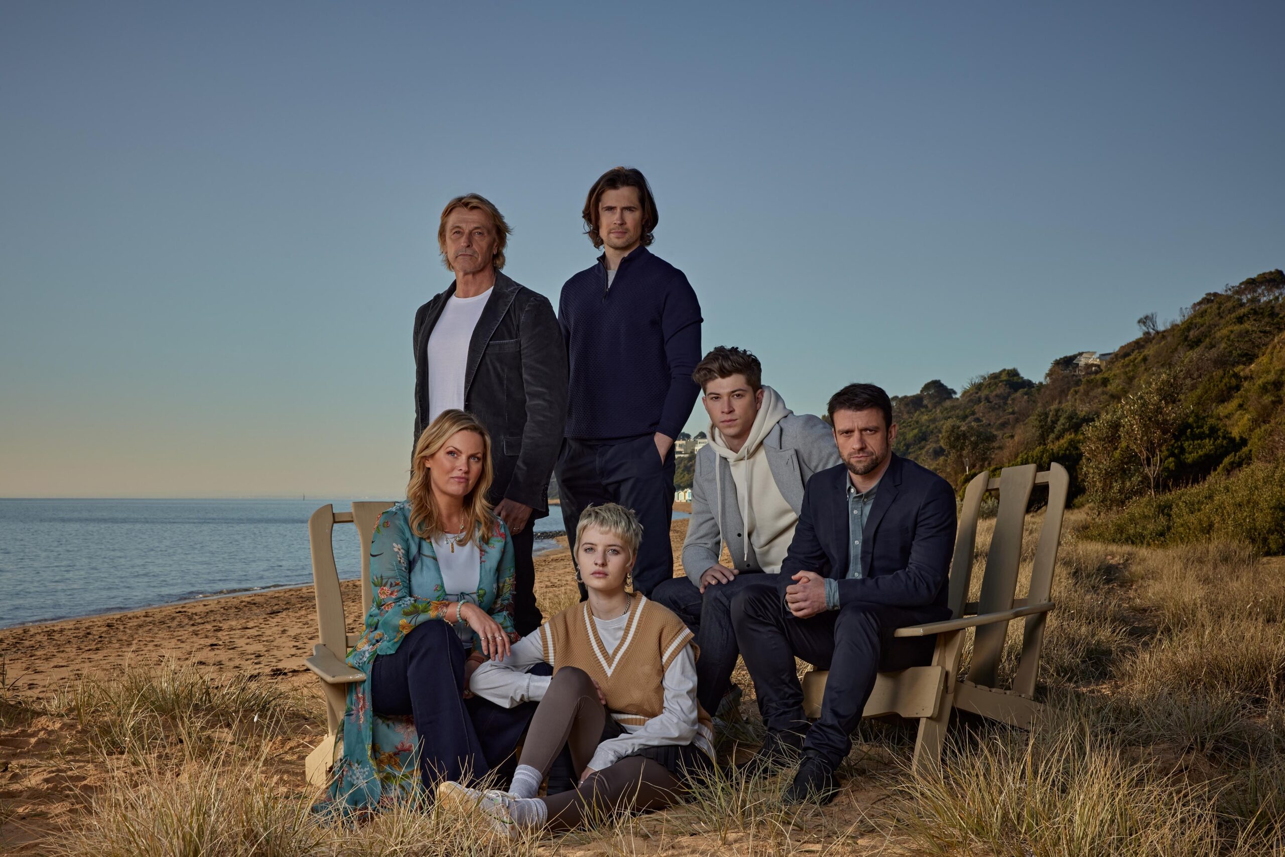 The cast of Riptide pose on the beach