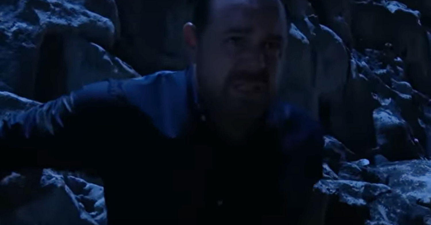 EastEnders' Mick is holding on to a cliff whilst looking worried