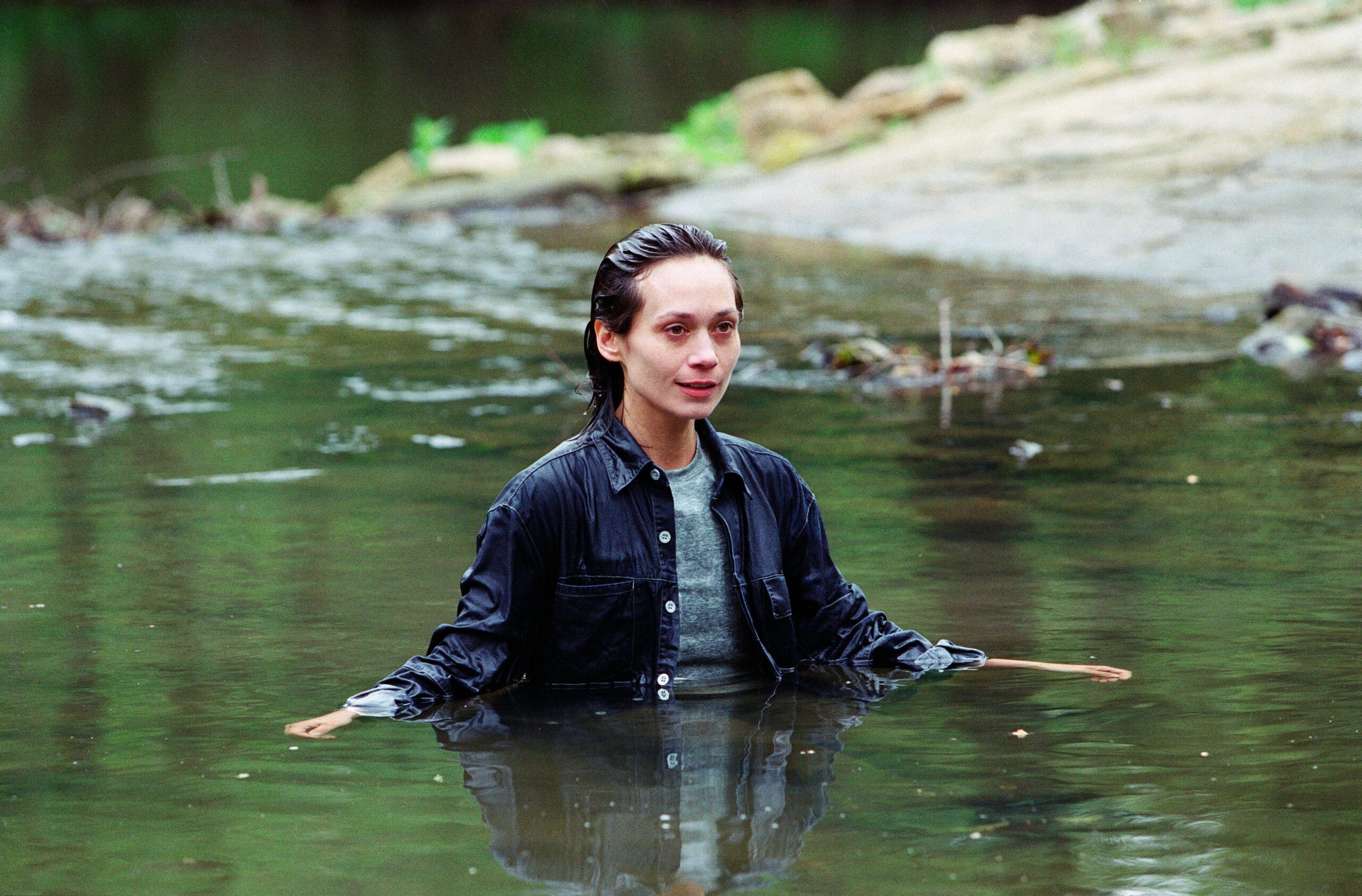 Zoe Tate stands fully clothed in the water in the midst of her mental health battle