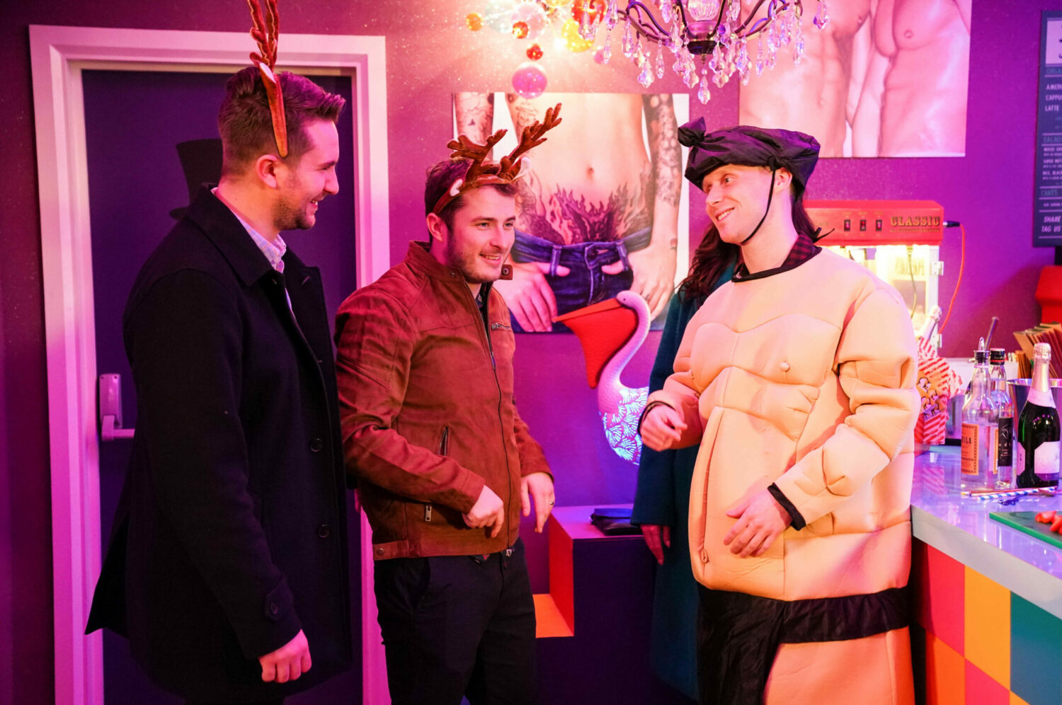 Callum, Ben and Jay laugh in costumes at Jay's stag do in EastEnders