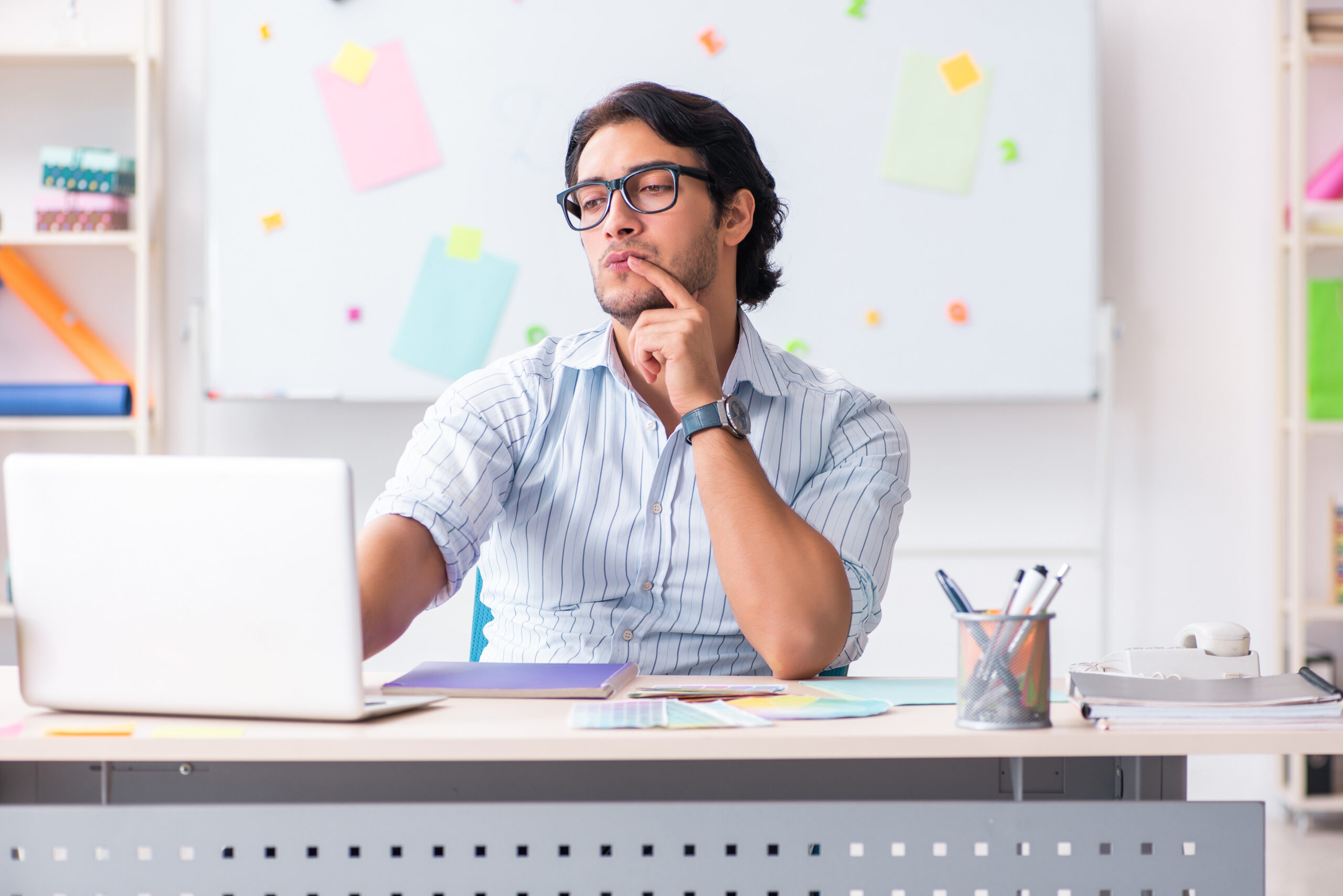 Man wearing glasses concentrating at a laptop