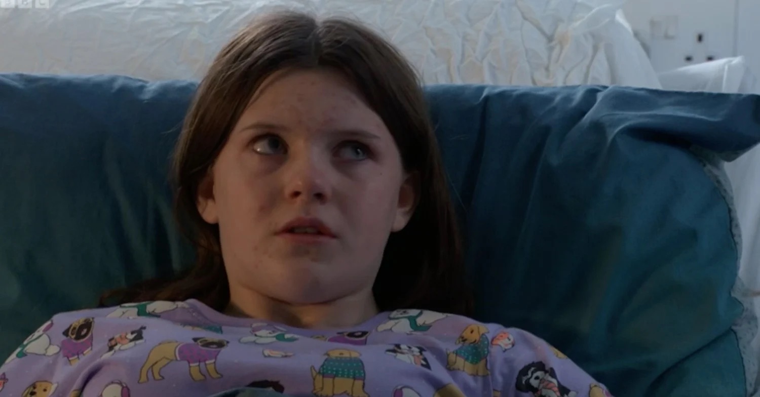 Lily Slater laying on a hospital bed in EastEnders