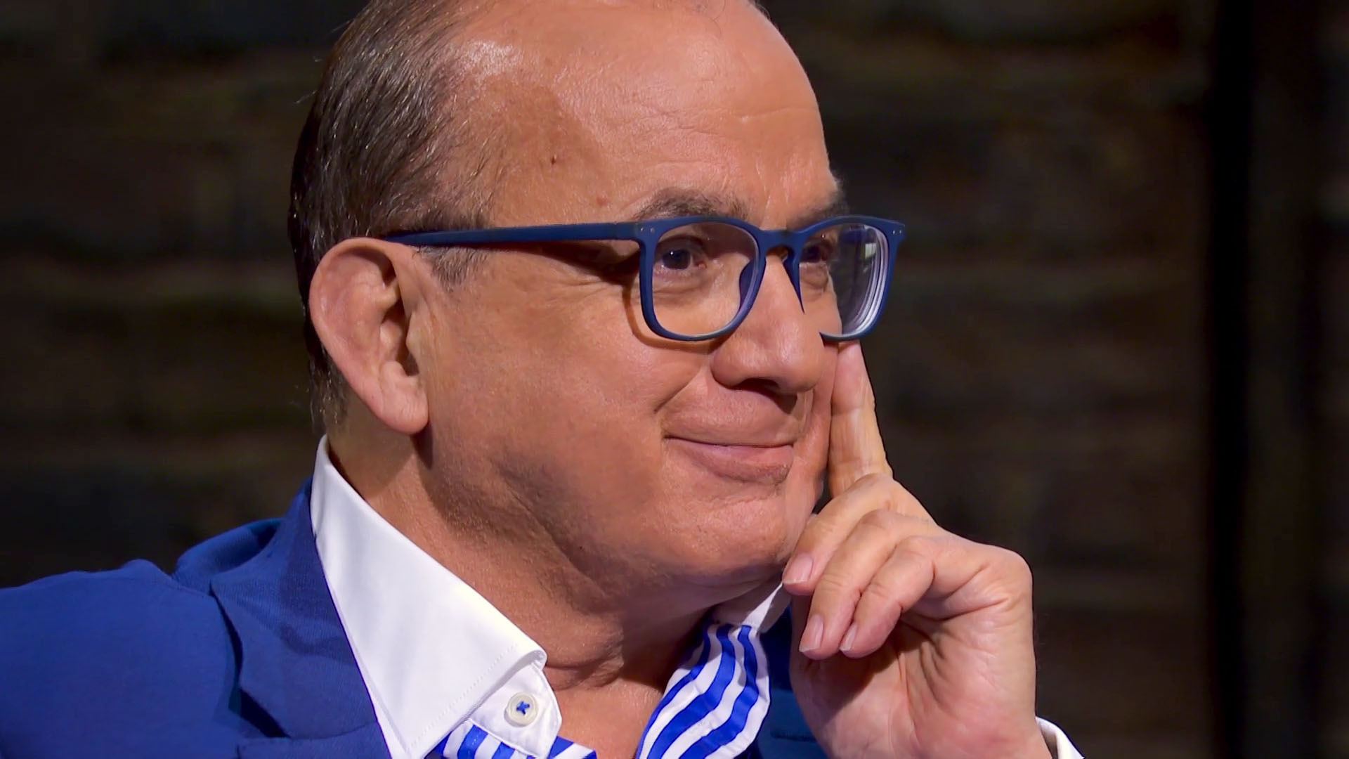 Touker Suleyman holding his hand up to his face on Dragons' Den