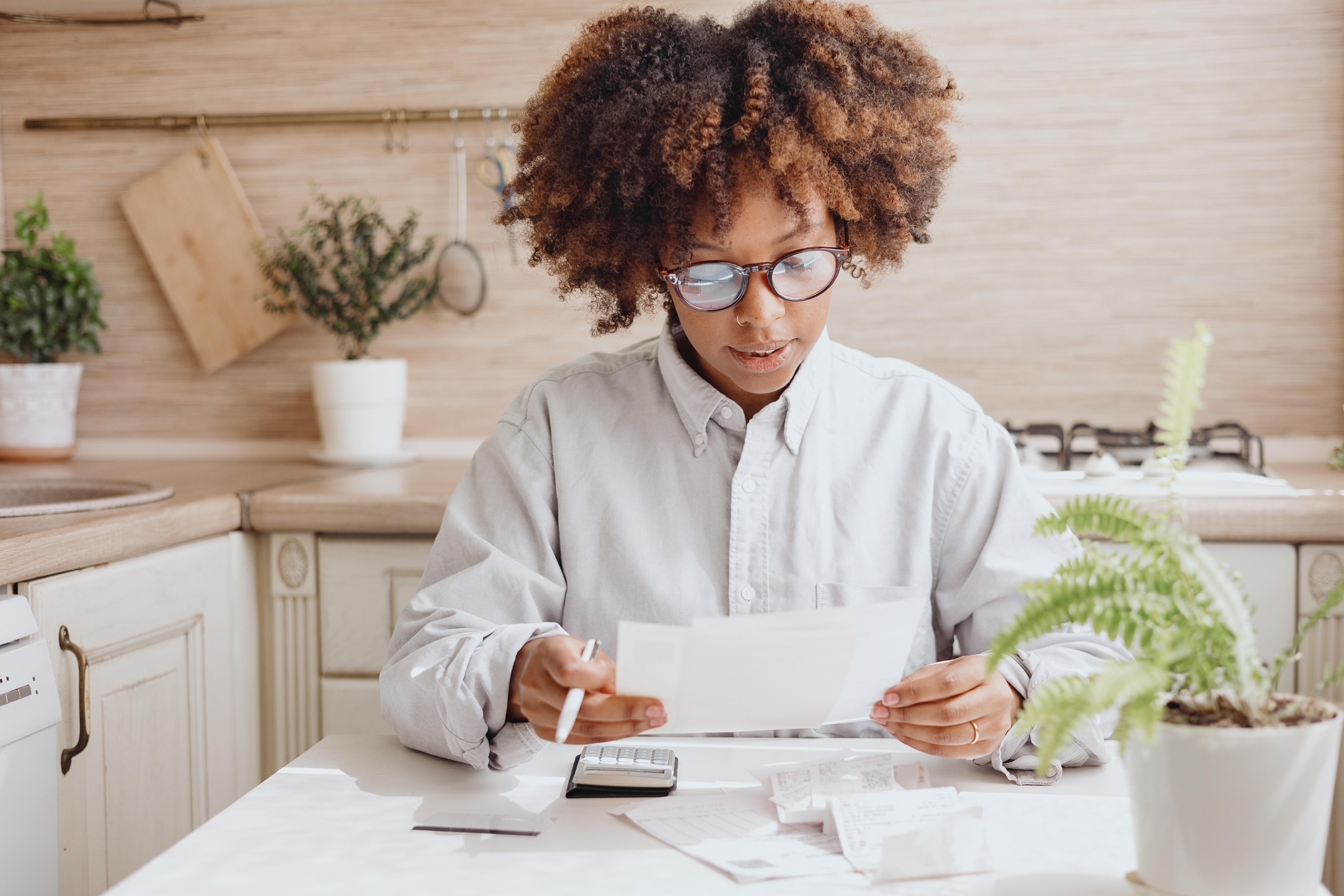 Woman looking at her bills wearing glasses