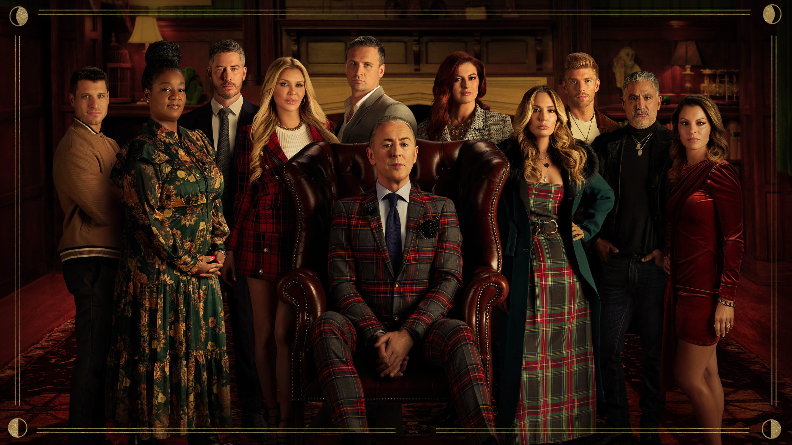 Alan Cumming smiles with the Traitor US contestants