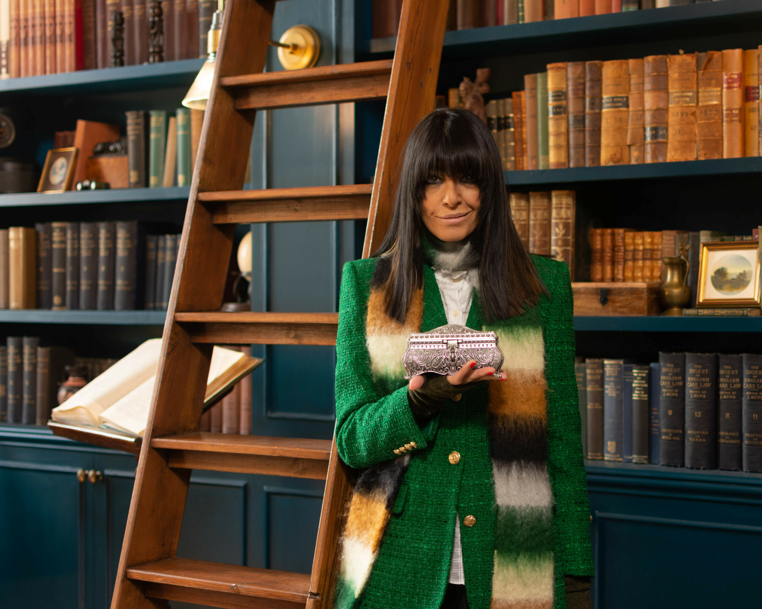 Claudia Winkleman poses with a box for The Traitors