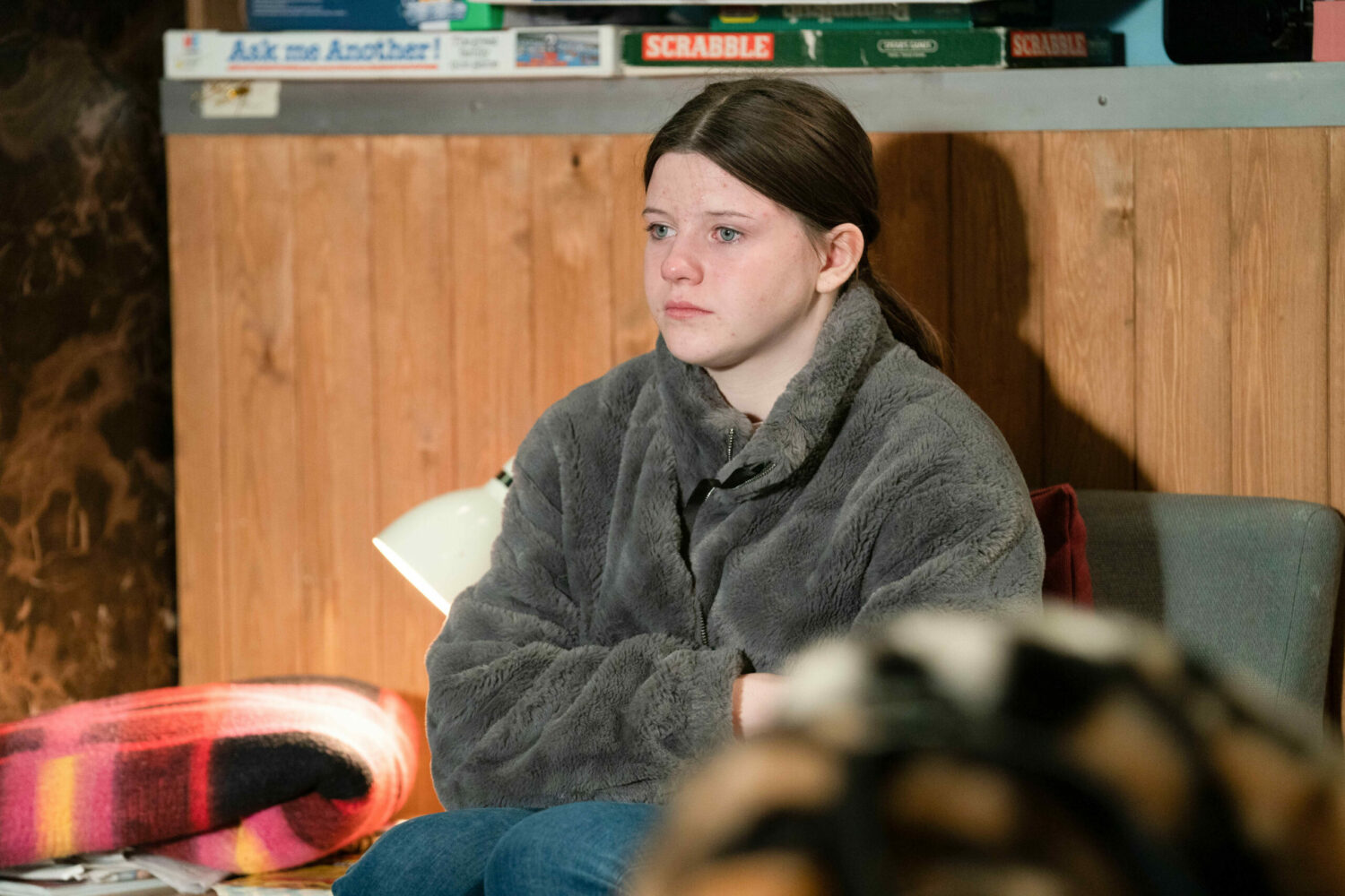 EastEnders' Lily is looking worried, sitting and staring into space