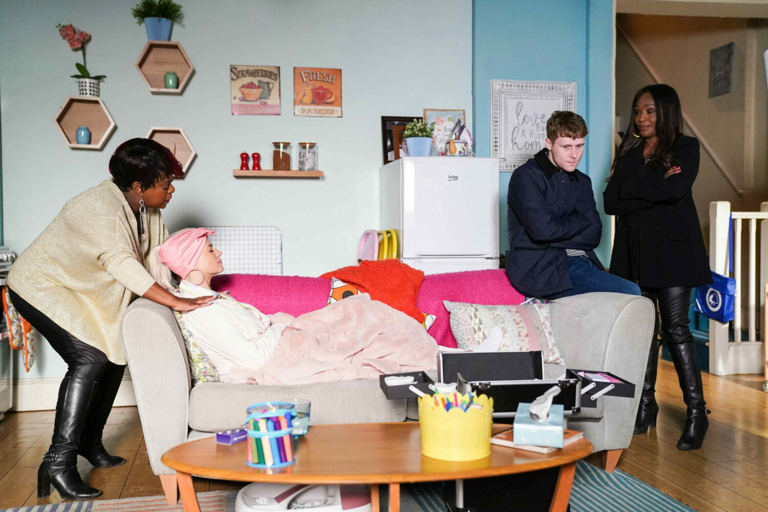 EastEnders: Lola lies on the sofa with Kim behind her and Jay and Denise looking concerned