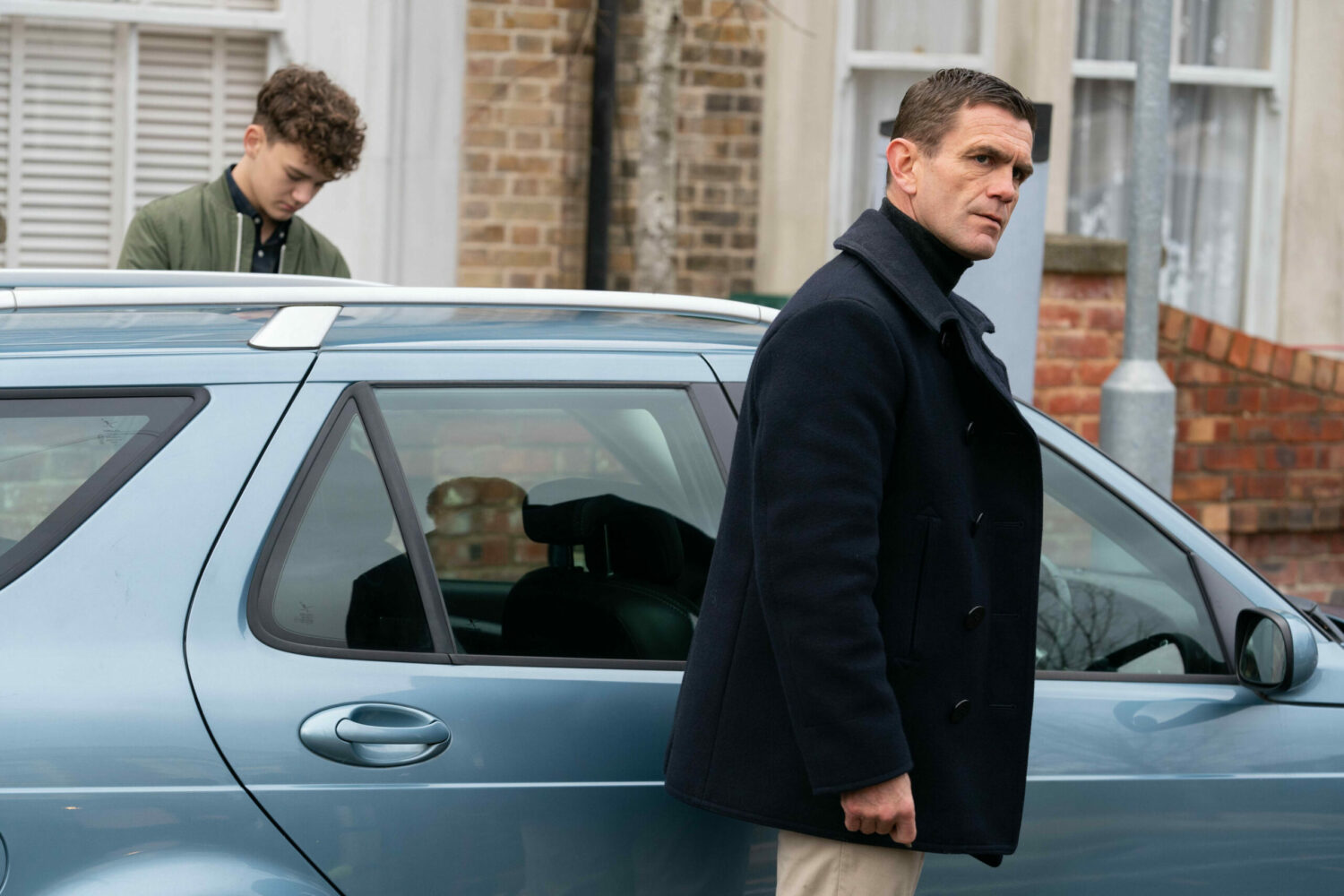 Jack and Ricky - looking grim-faced - get into Jack's car