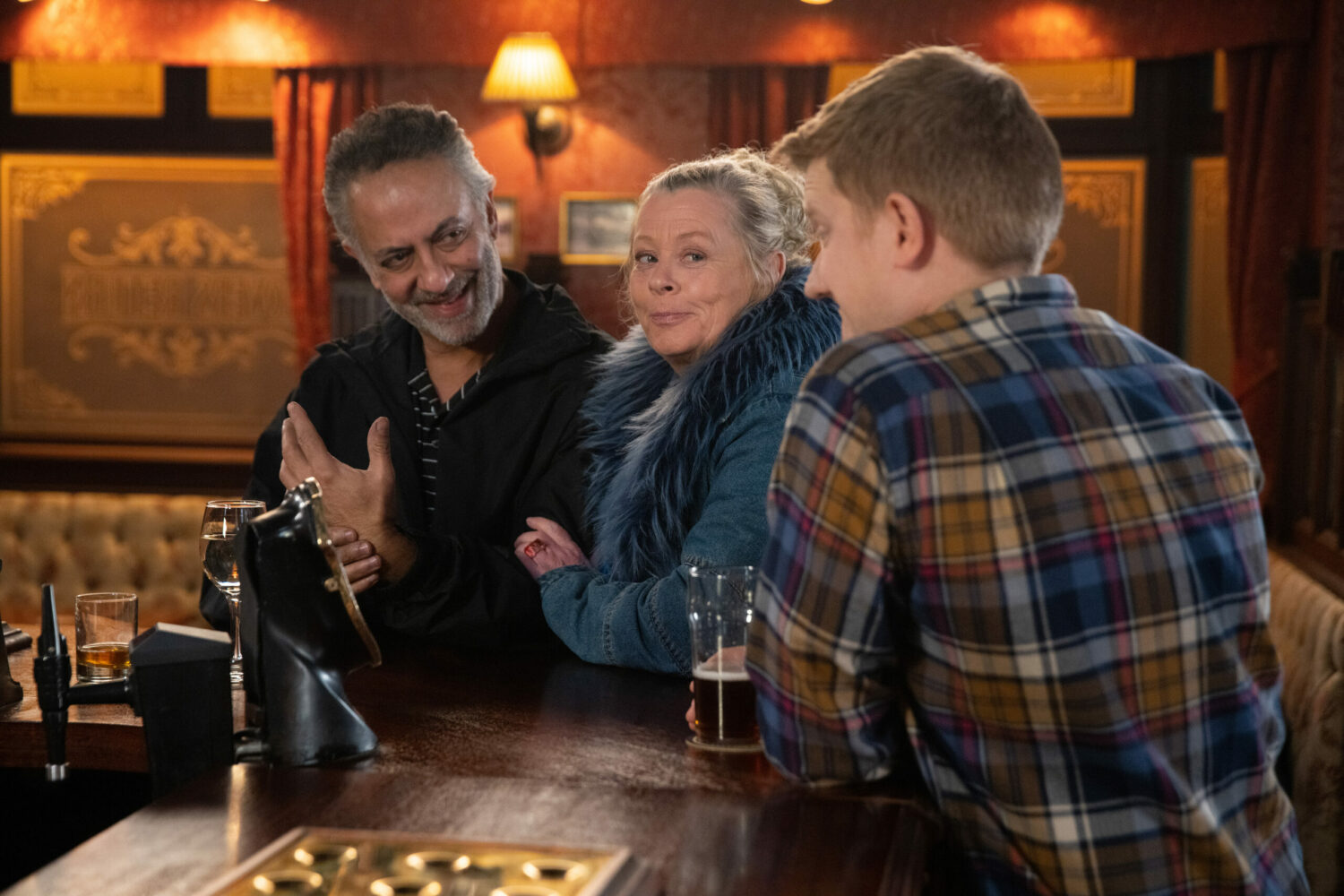 Dev and Bernie smile smugly at Chesney in the Rovers in Coronation Street