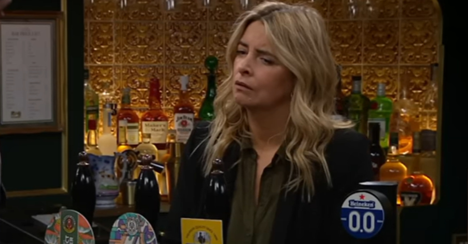 Charity is looking angry behind the bar in Emmerdale