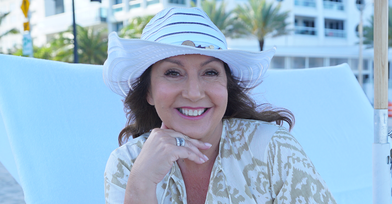Jane McDonald smiling wearing a hat