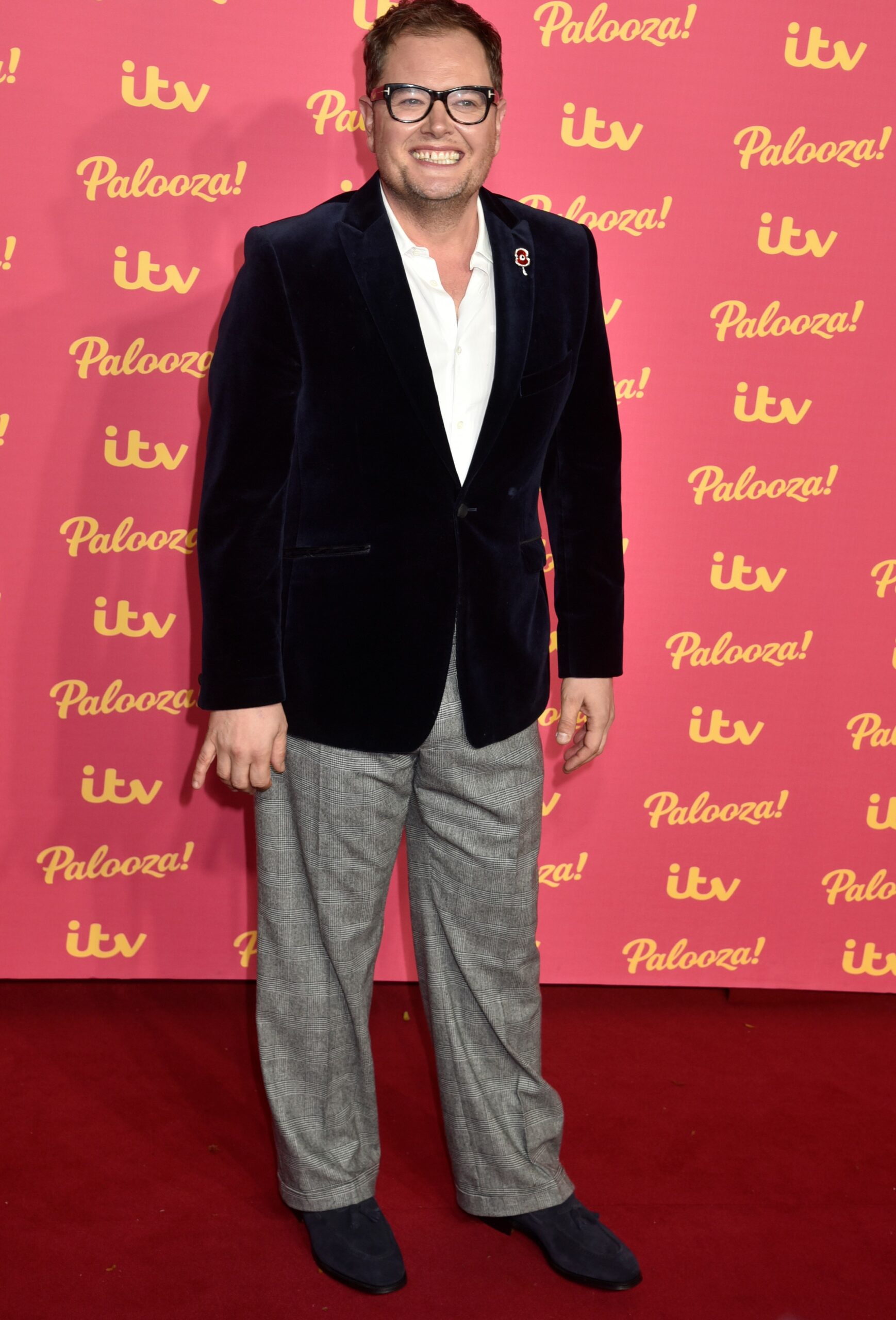 Alan Carr smiling in suit at ITV Palooza