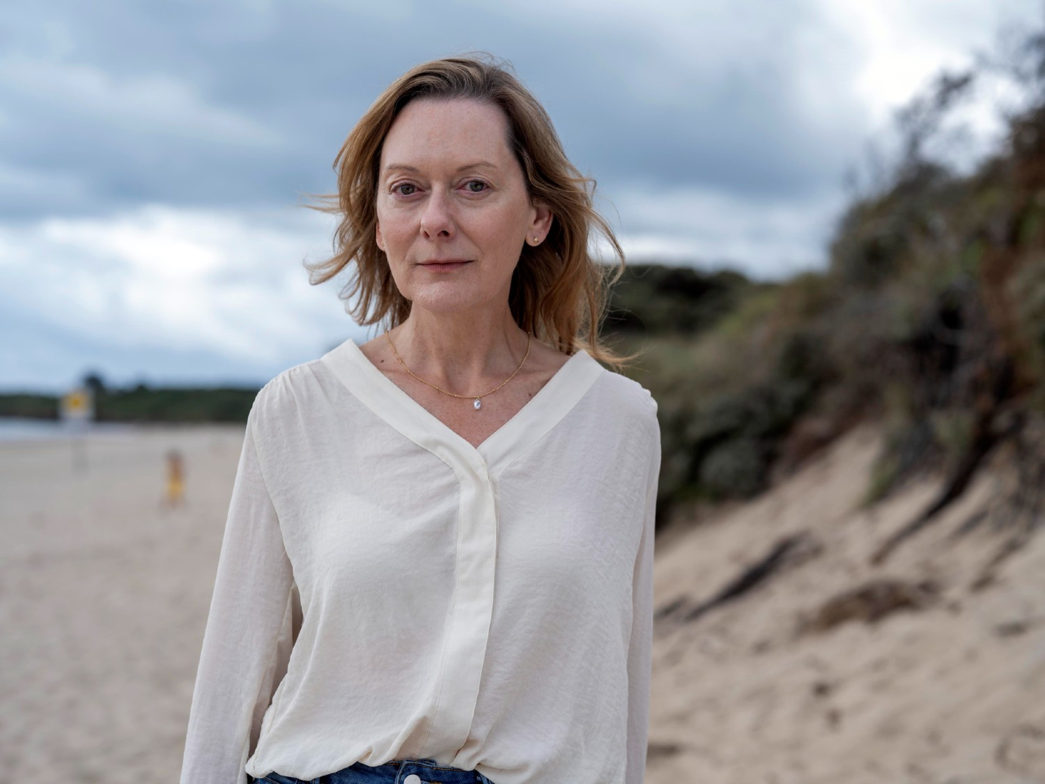 Cathy Belton wearing a white shirt on the beach in The Catch