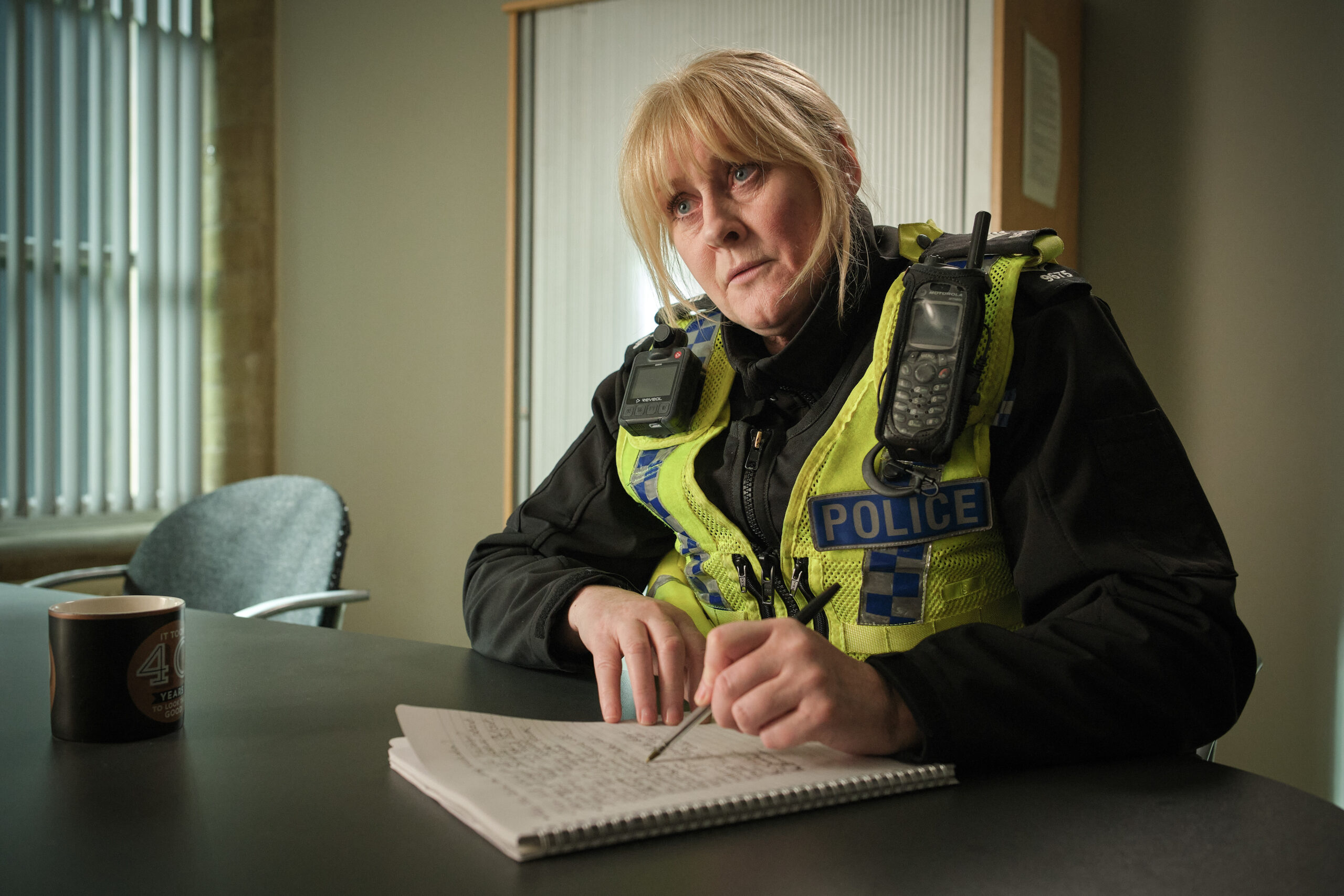 Catherine Cawood sat at a desk in Happy Valley series 3