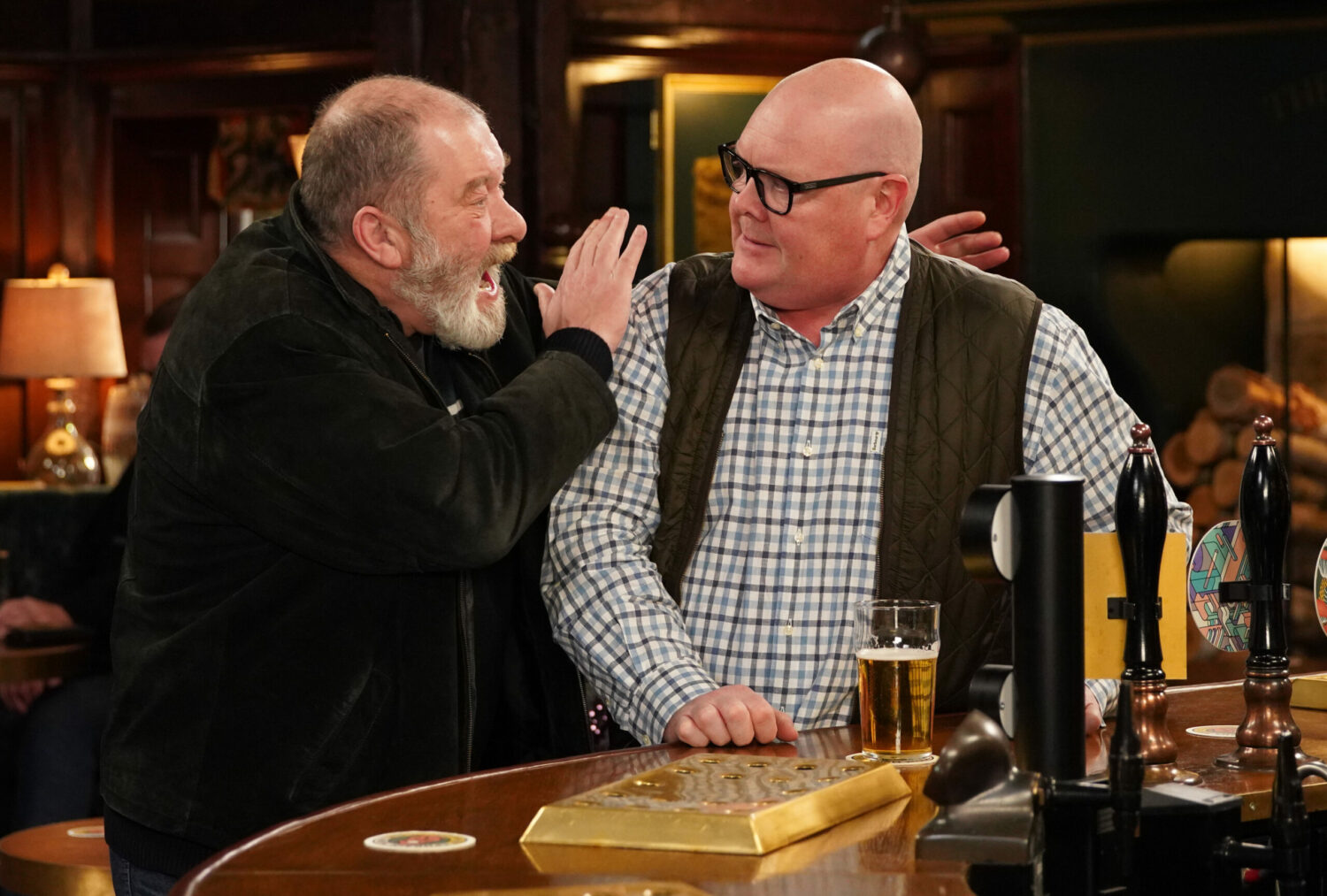 Emmerdale's Bear is looking animated whilst speaking to an unsure Paddy at the bar