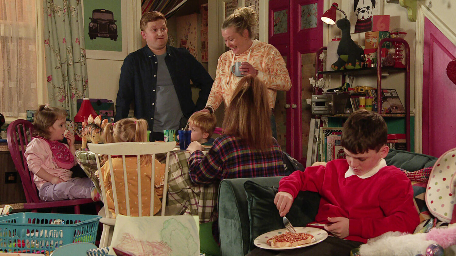 Chesney looks disbelieving while talking to Bernie, surrounded by the kids at No.5 on Corrie