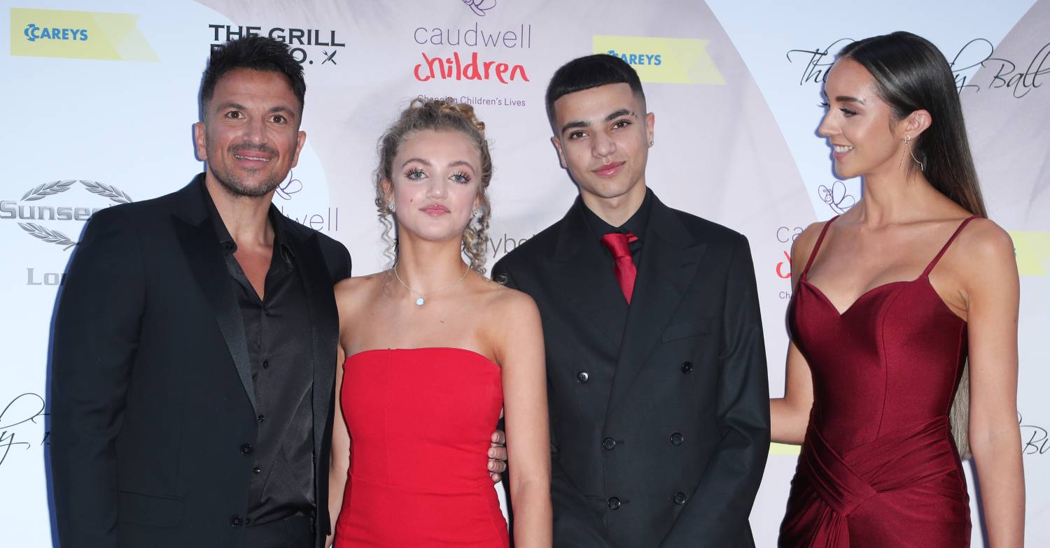 Peter Andre stands with his family