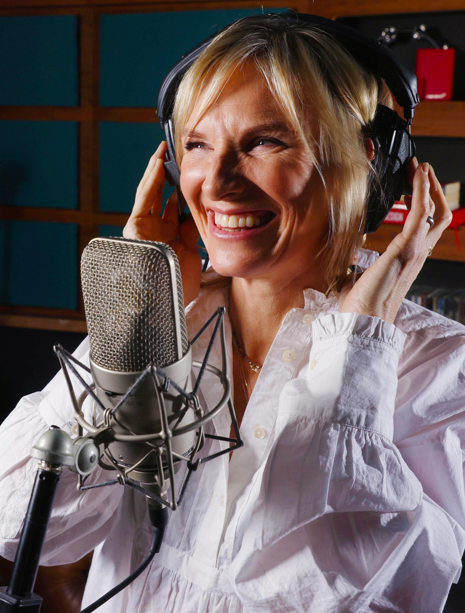 Jo Whiley standing behind a microphone talking about holidays