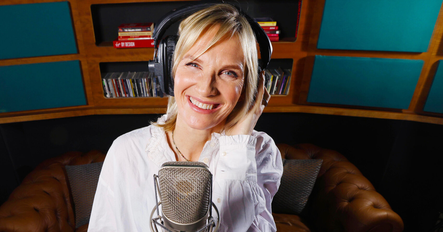 Jo Whiley standing behind a microphone talking about holidays