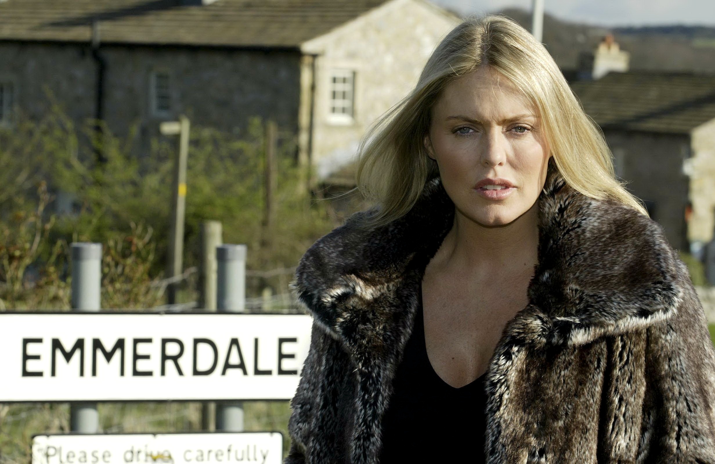 Emmerdale's Patsy Kensit is standing outside of the Emmerdale sign, as Sadie King