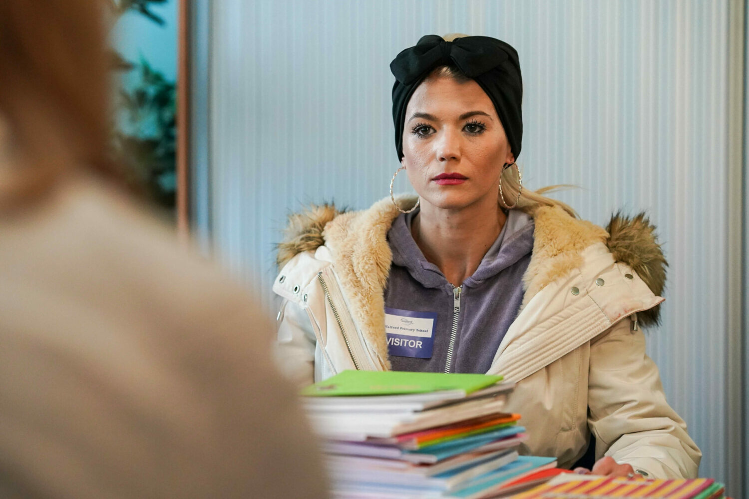 EastEnders' Lola is holding books whilst looking shocked