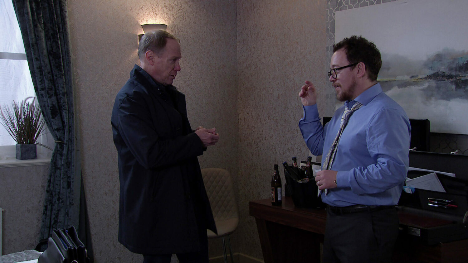 Stephen talks with dodgy-looking Rufus in a hotel room on Coronation Street