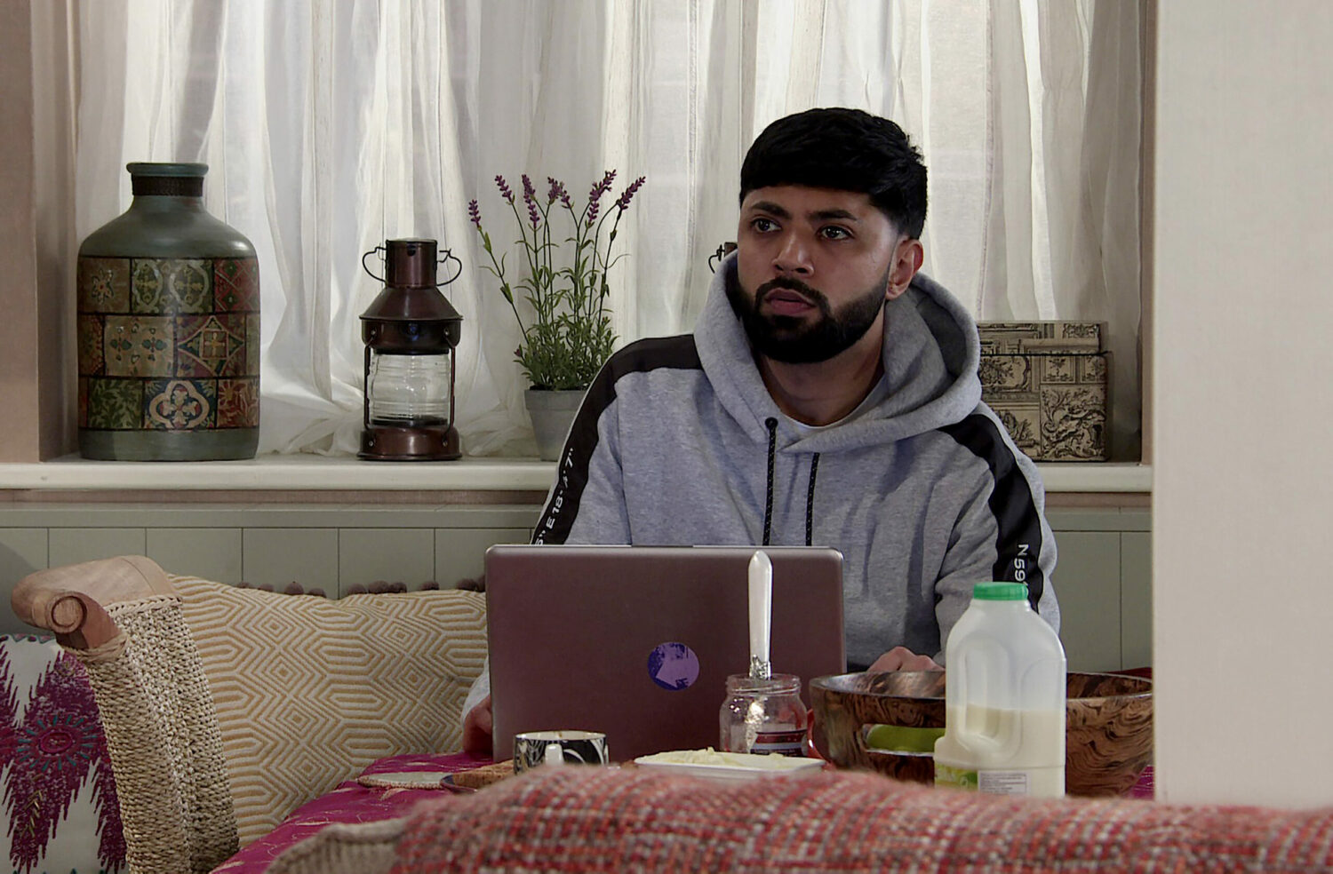Zeedan looks upset whilst on his laptop on Coronation Street