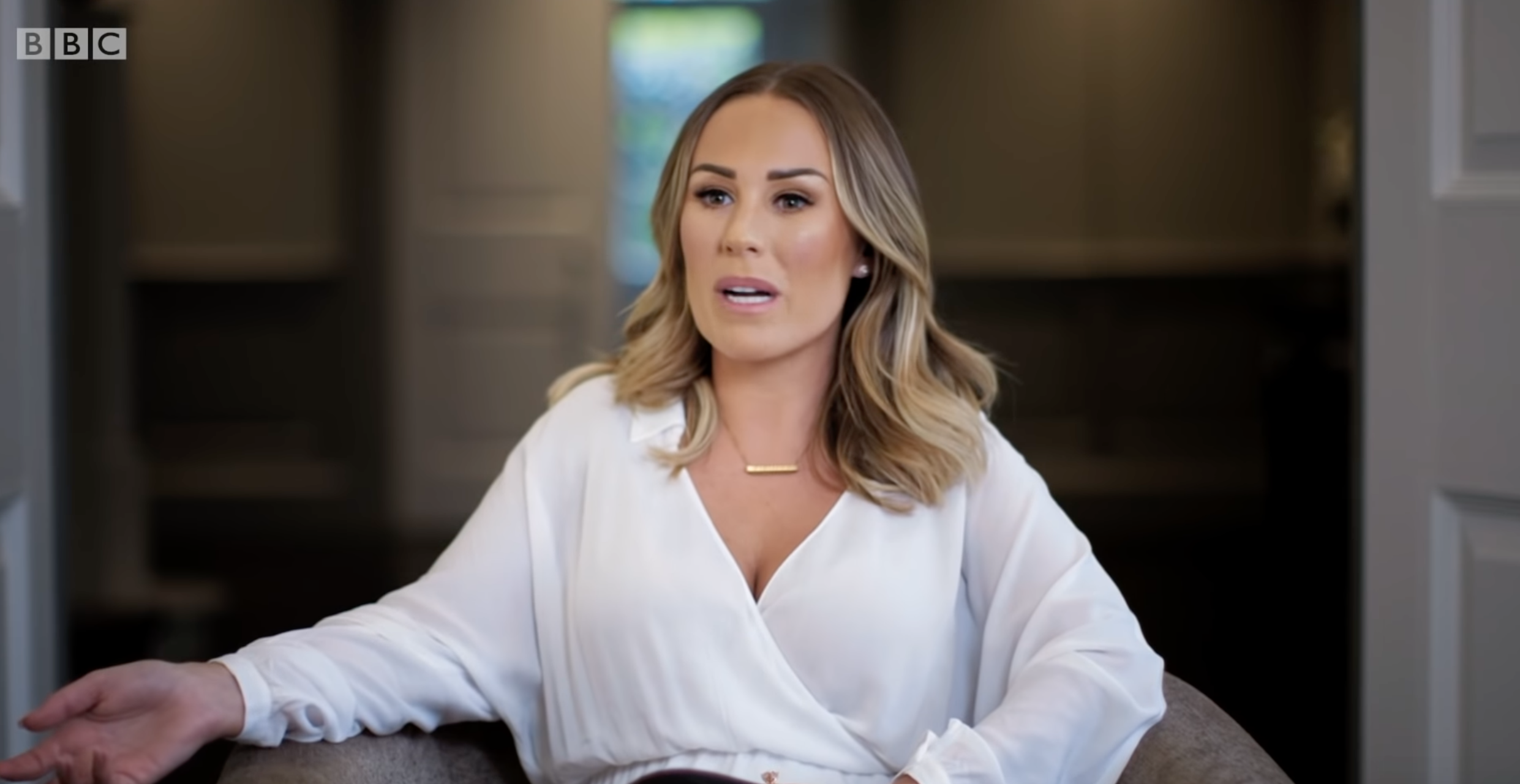 Kate Ferdinand sitting in a chair in a white blouse