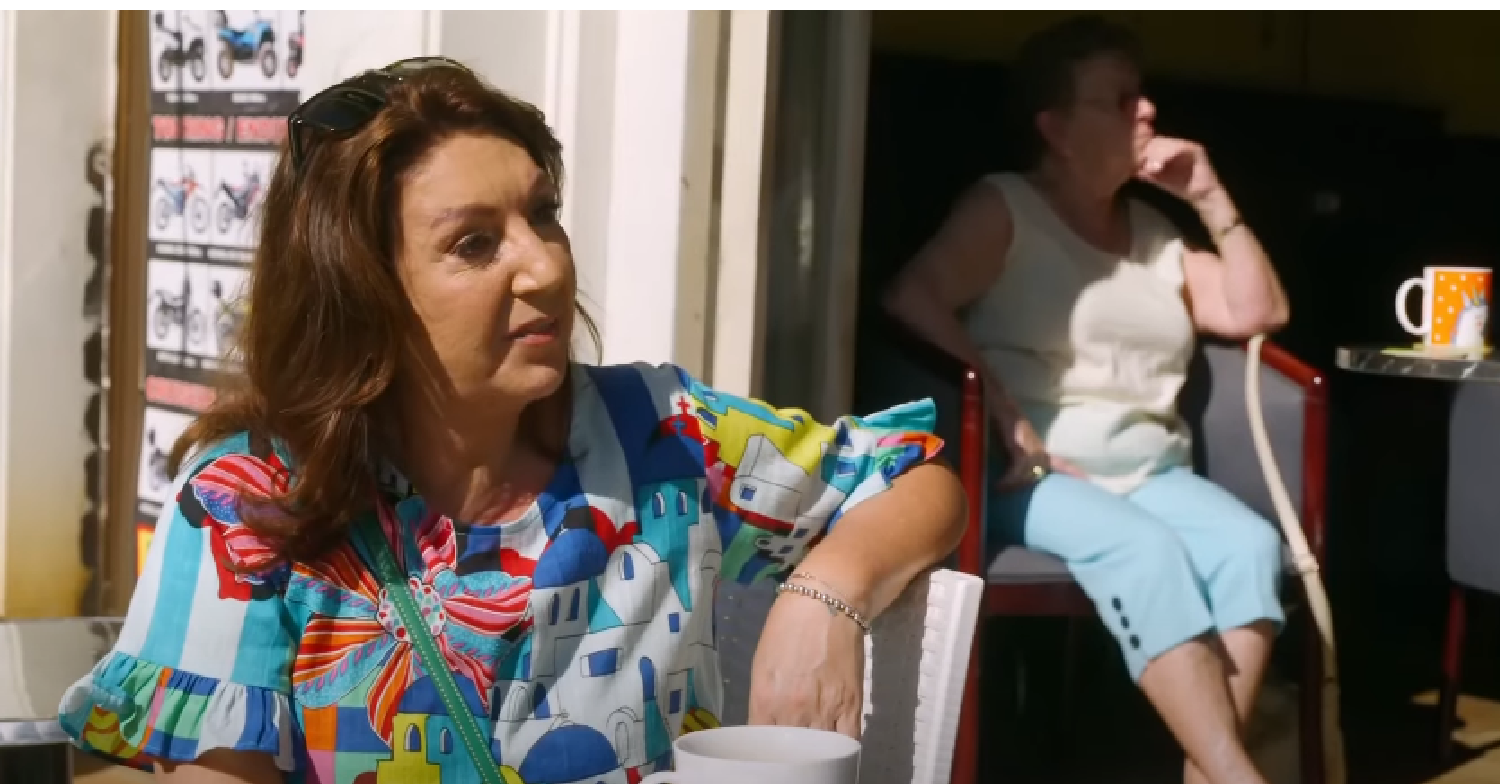 Jane McDonald sitting in the sun on her travel show