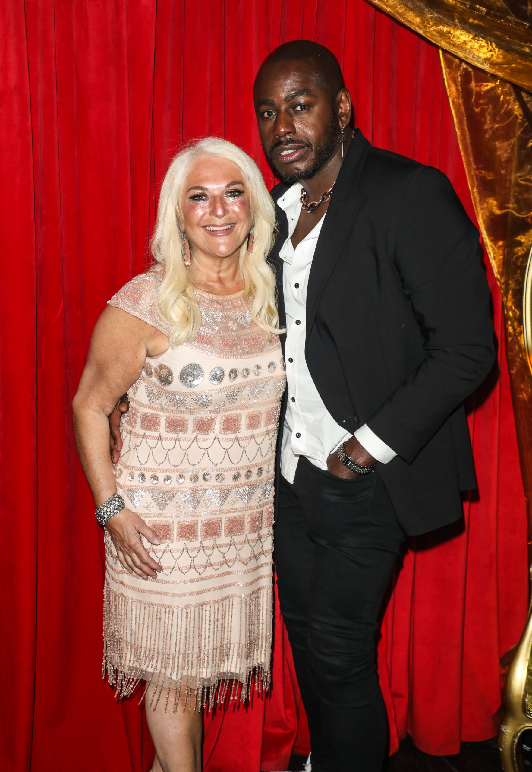 Vanessa Feltz smiling with Ben in front of a red curtain