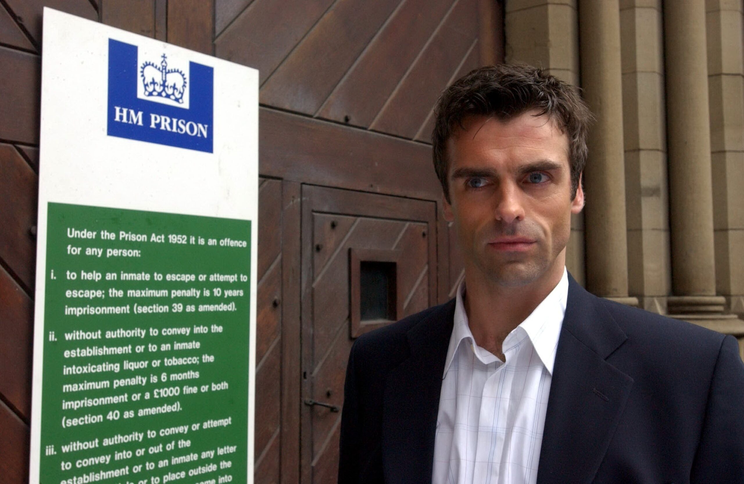 Joe Carter in Coronation Street next to the prison sign