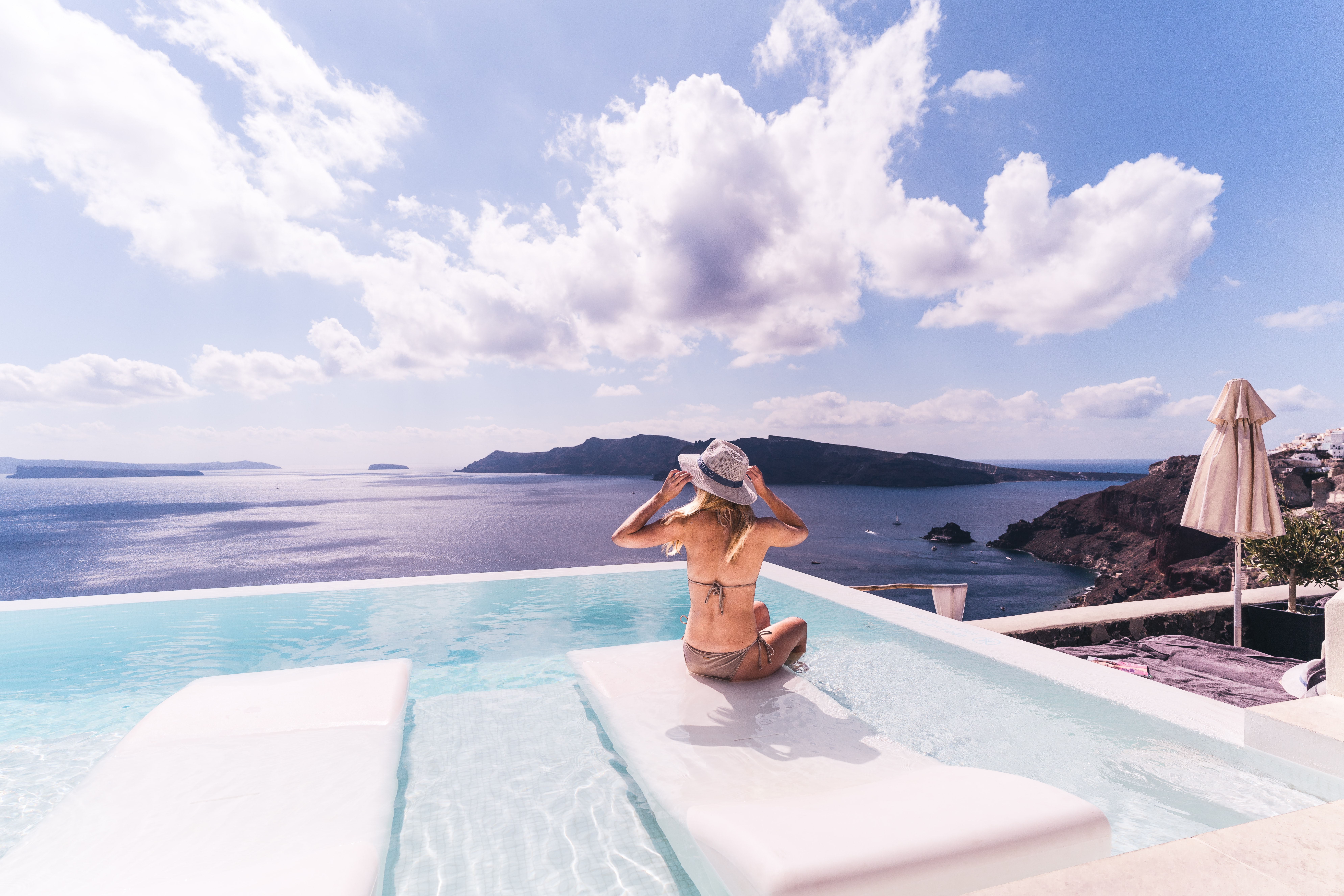 Woman sitting at the edge of a pool on her holidays