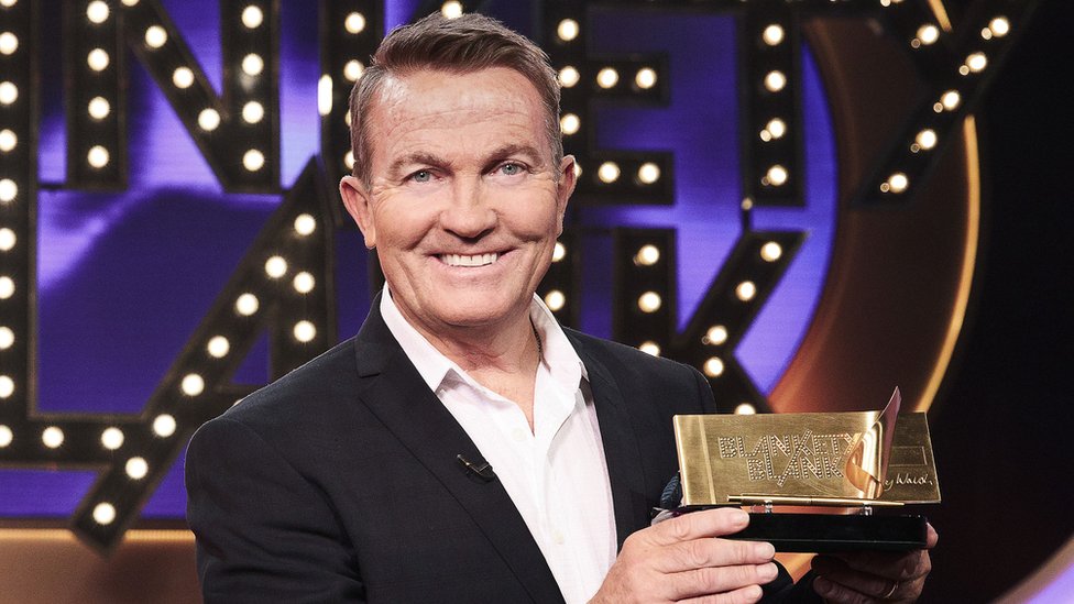 Bradley Walsh smiles with Blankety Blank chequebook
