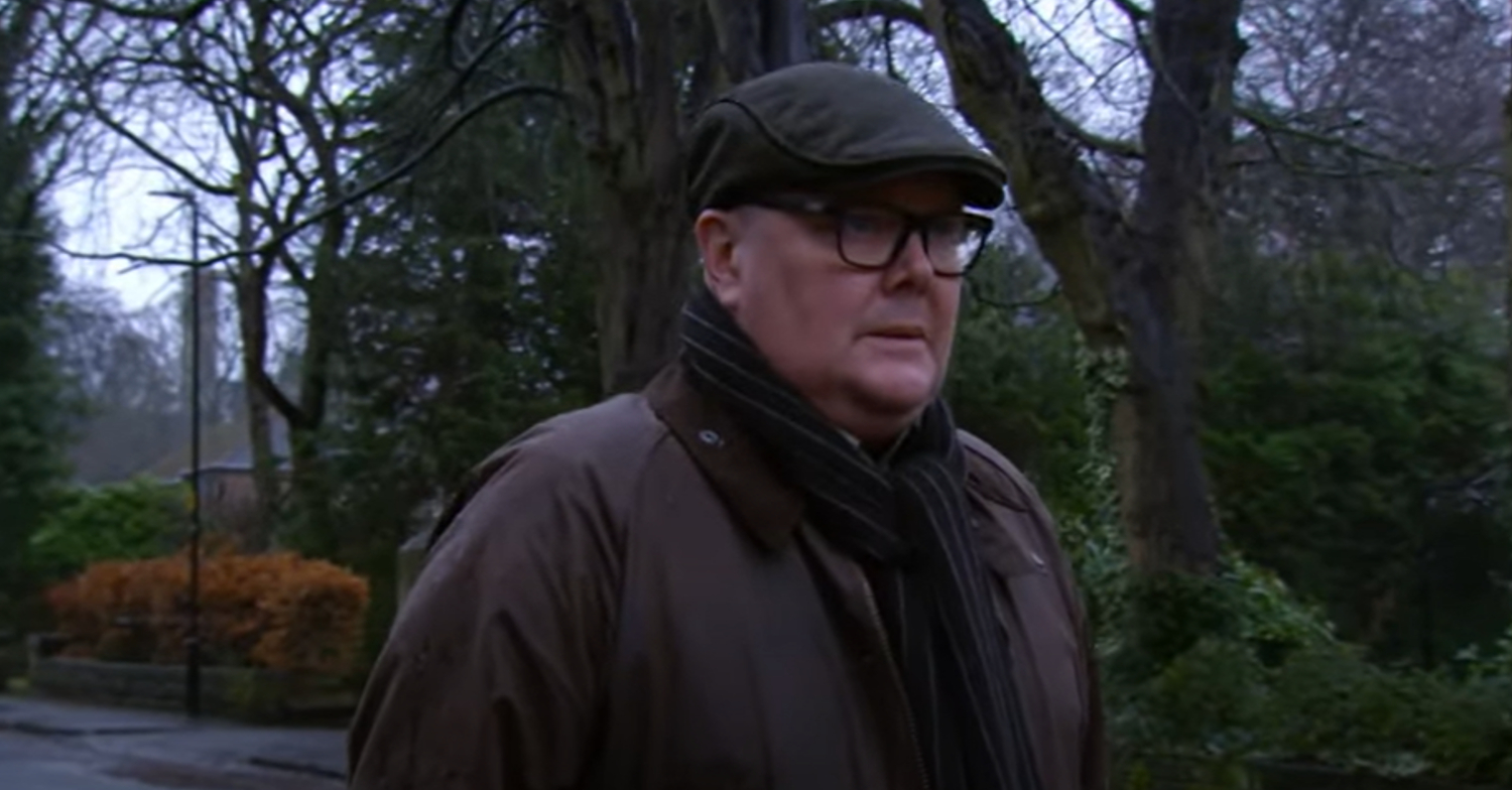 Emmerdale's Paddy is looking into the distance whilst wearing a cap