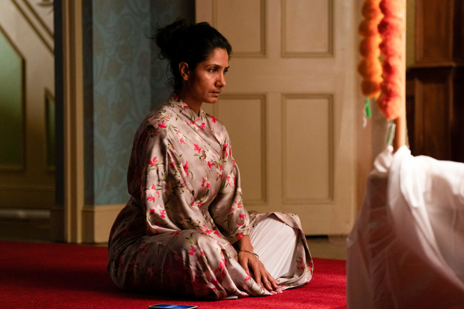 Suki looks contemplative as she sits on the floor in her pyjamas on EastEnders