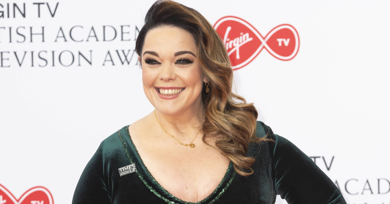 Lisa Riley posing for photos wearing velvet green dress