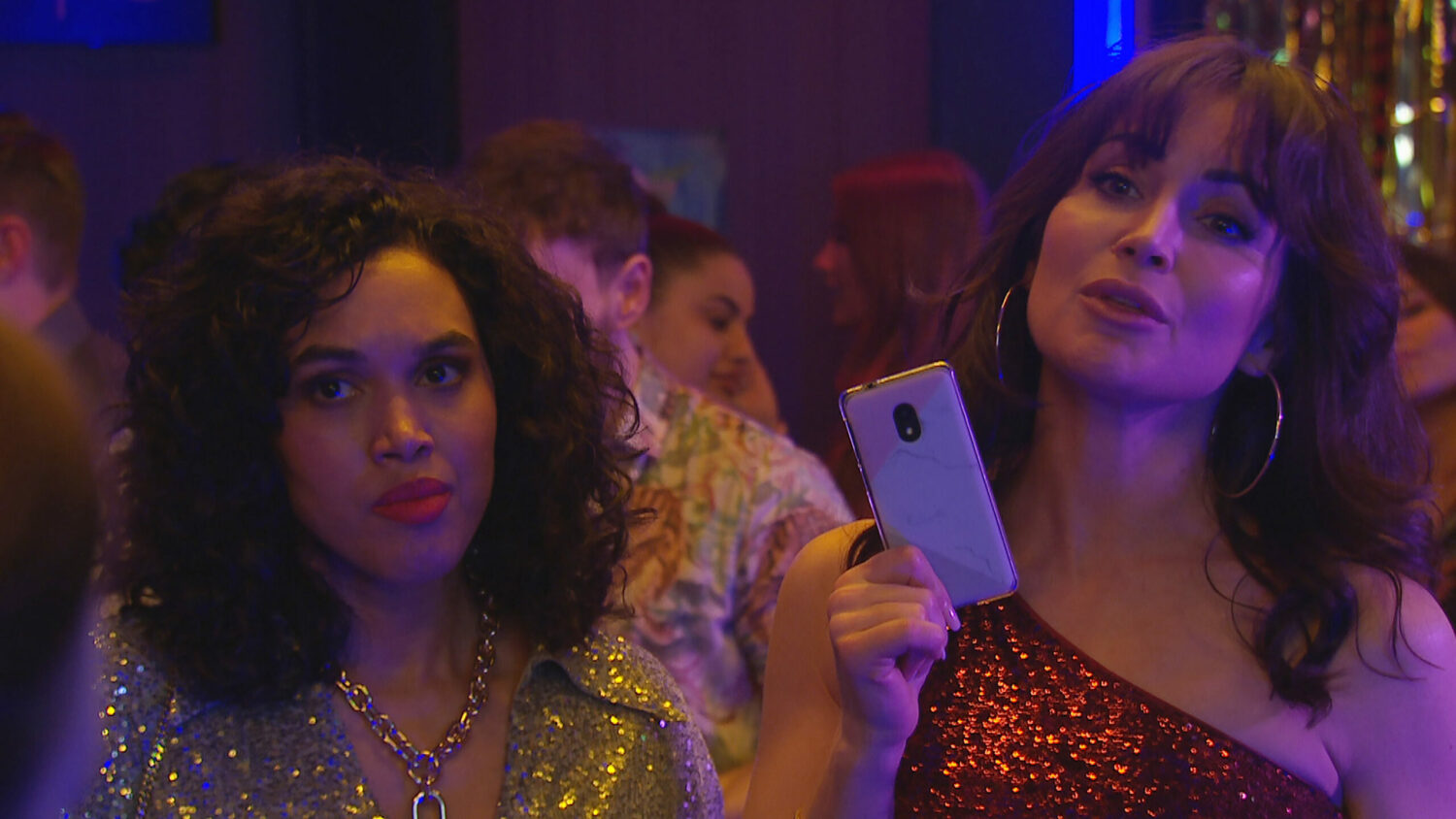 Leyla looks pleased with herself as she confronts Callum with her phone; Suzy standing next to her in Emmerdale