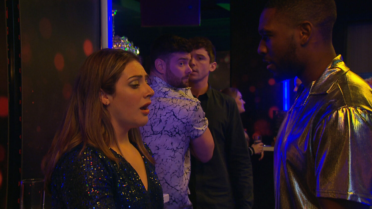 Victoria having a panic attack while a man looks at her in a bar on Emmerdale