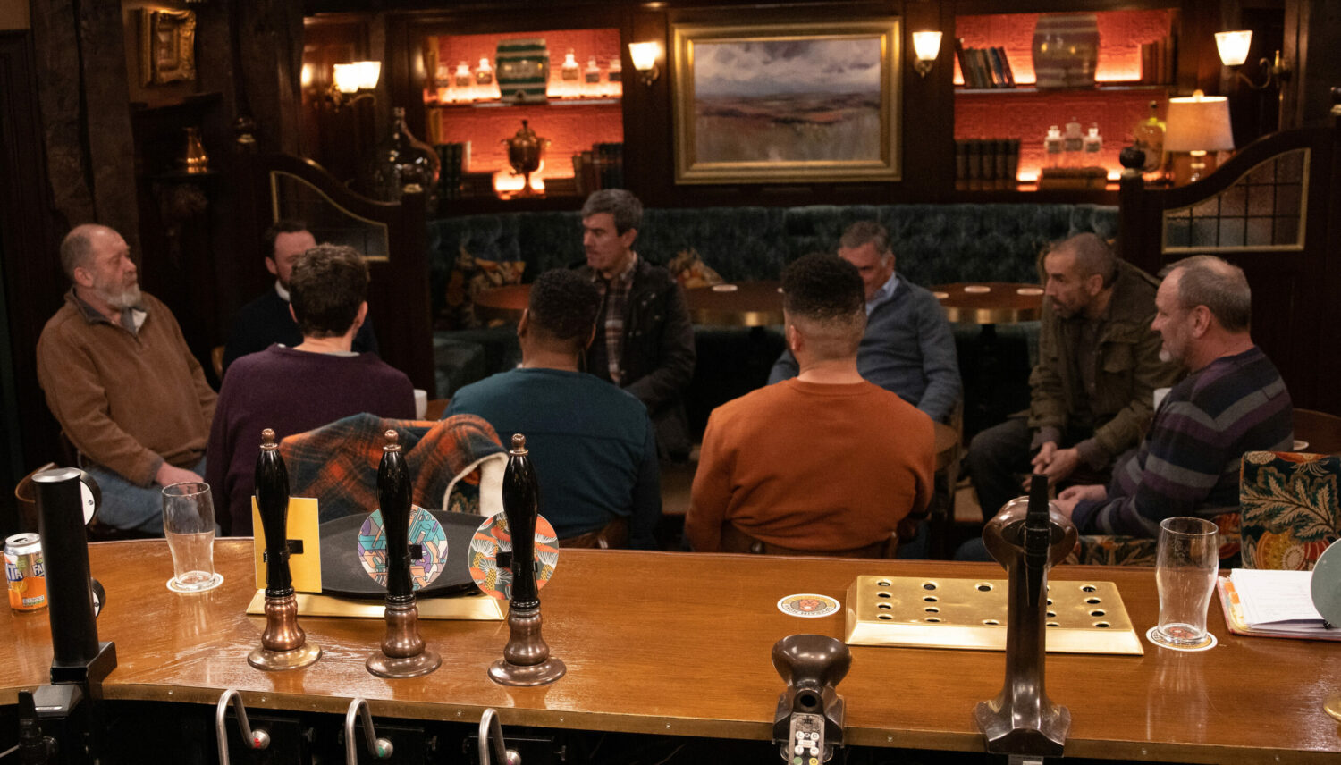 Emmerdale's male villagers are sat in a circle in The Woolpack
