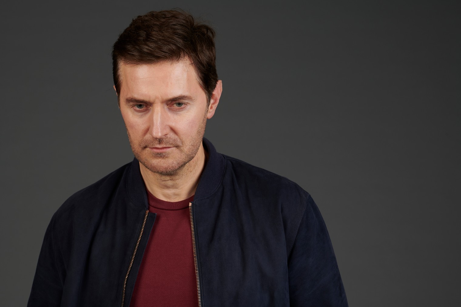 Adam Price frowns in The Stranger