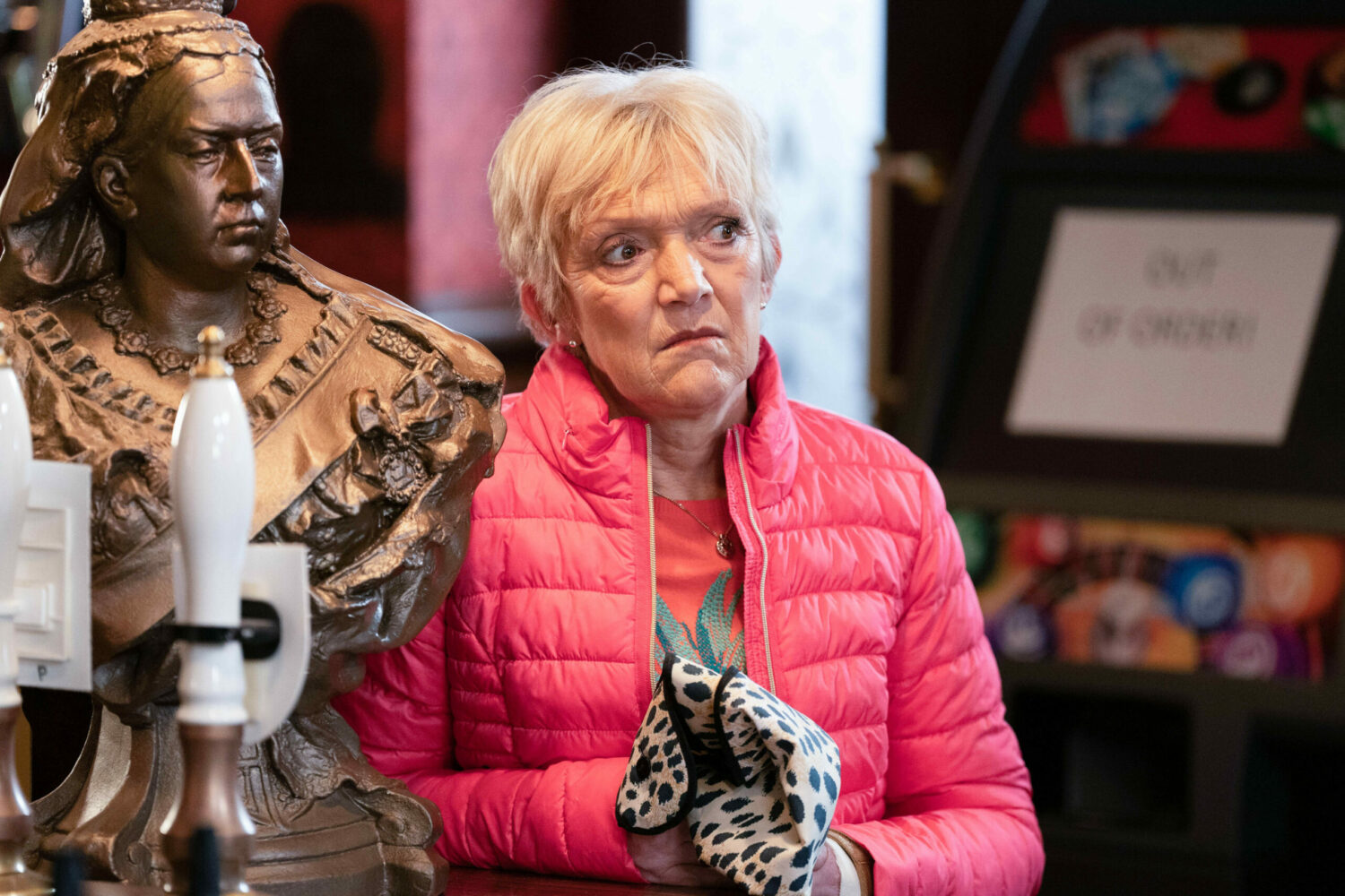Jean is thoughtful in EastEnders next to The Queen Vic bust